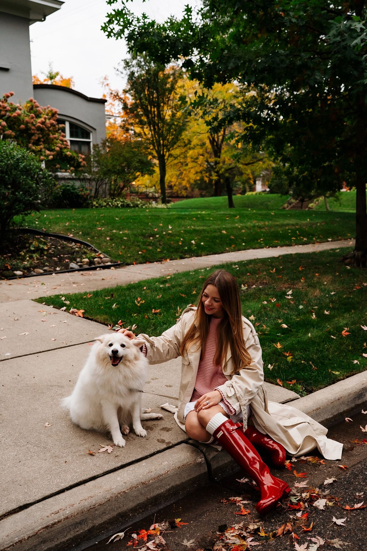 Woman cuddling her dog on the steps of a historic Heritage Hill home.