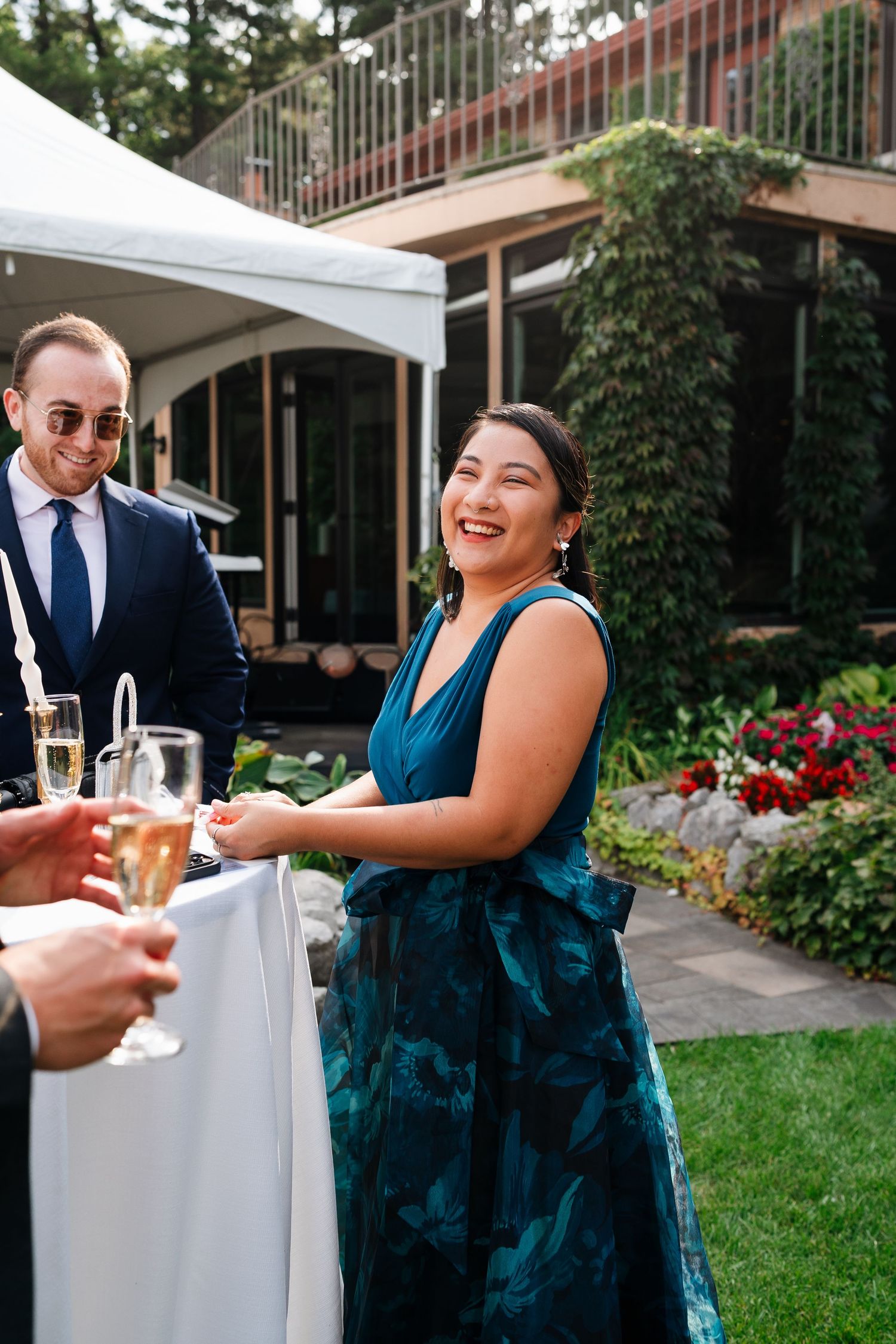 Wedding guest smiling while visiting with friends during an outdoor reception at Marigold Lodge.
