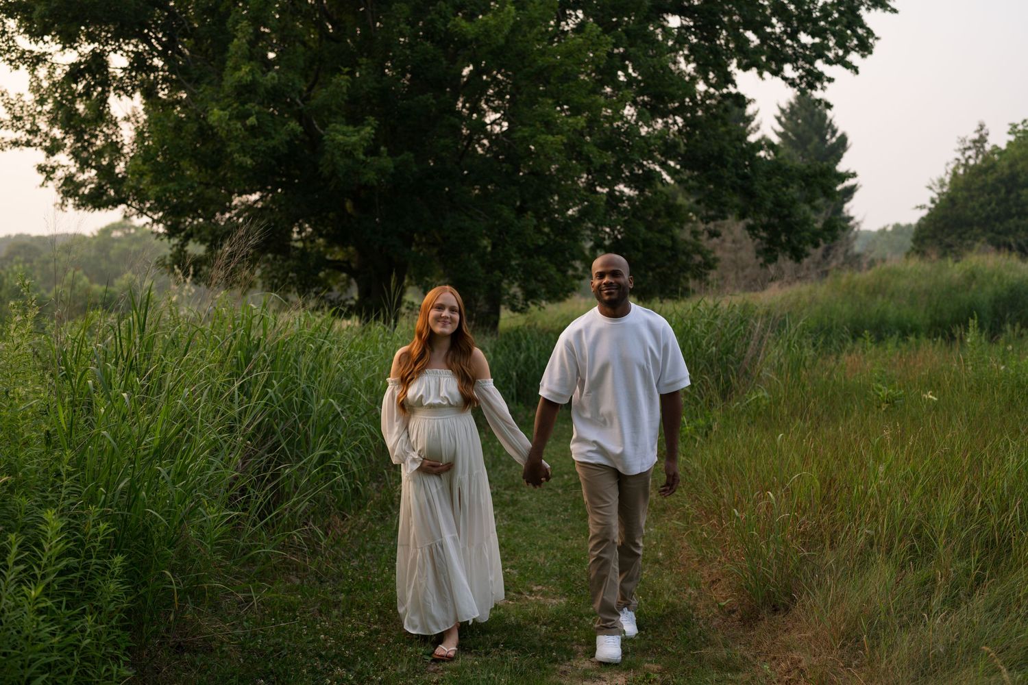 Expectant mother smiling as she cradles her baby bump at Highlands Prairie.