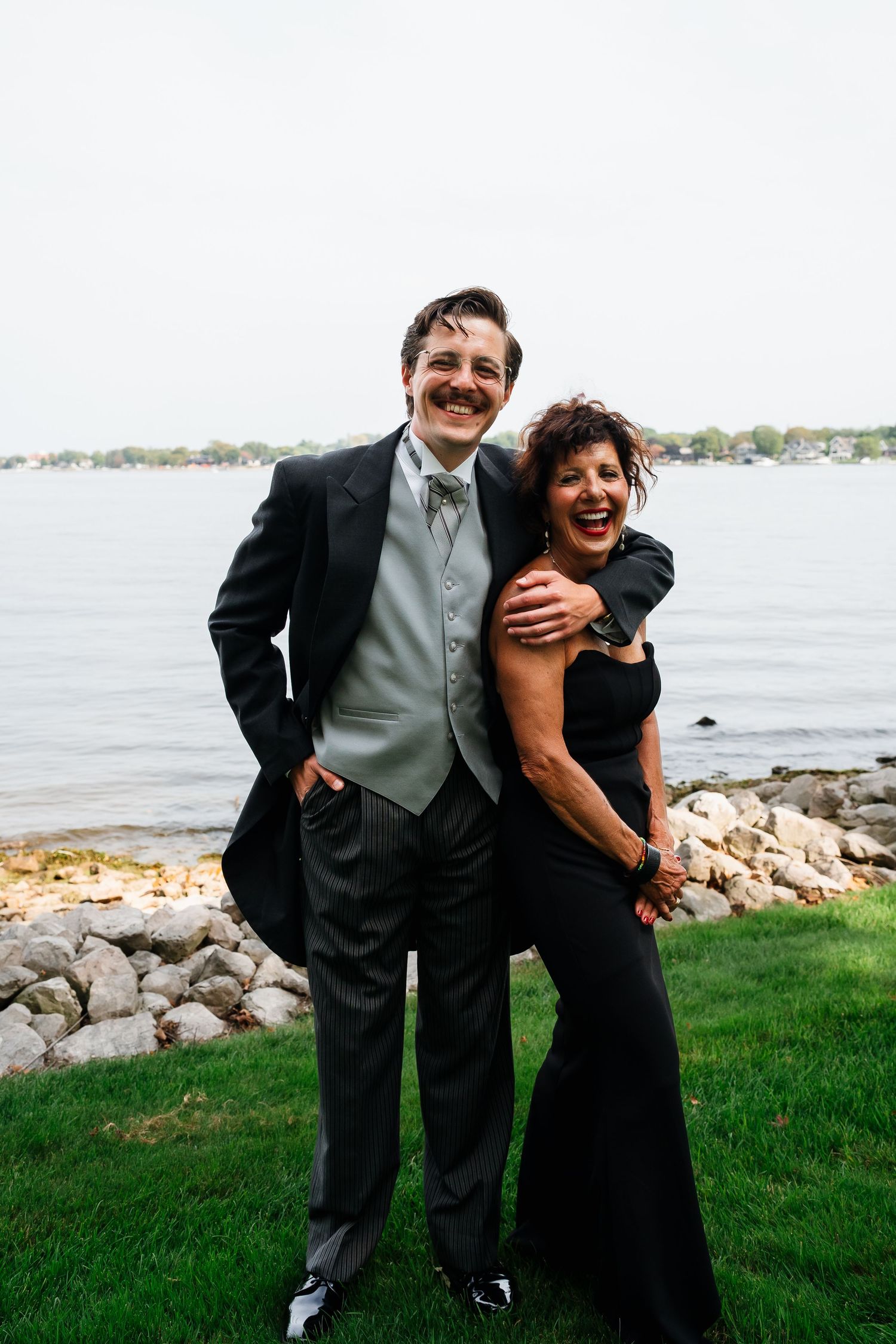 Mother and Son share a warm embrace before the ceremony at marigold lodge on lake michigan where there were gardens and flowers.