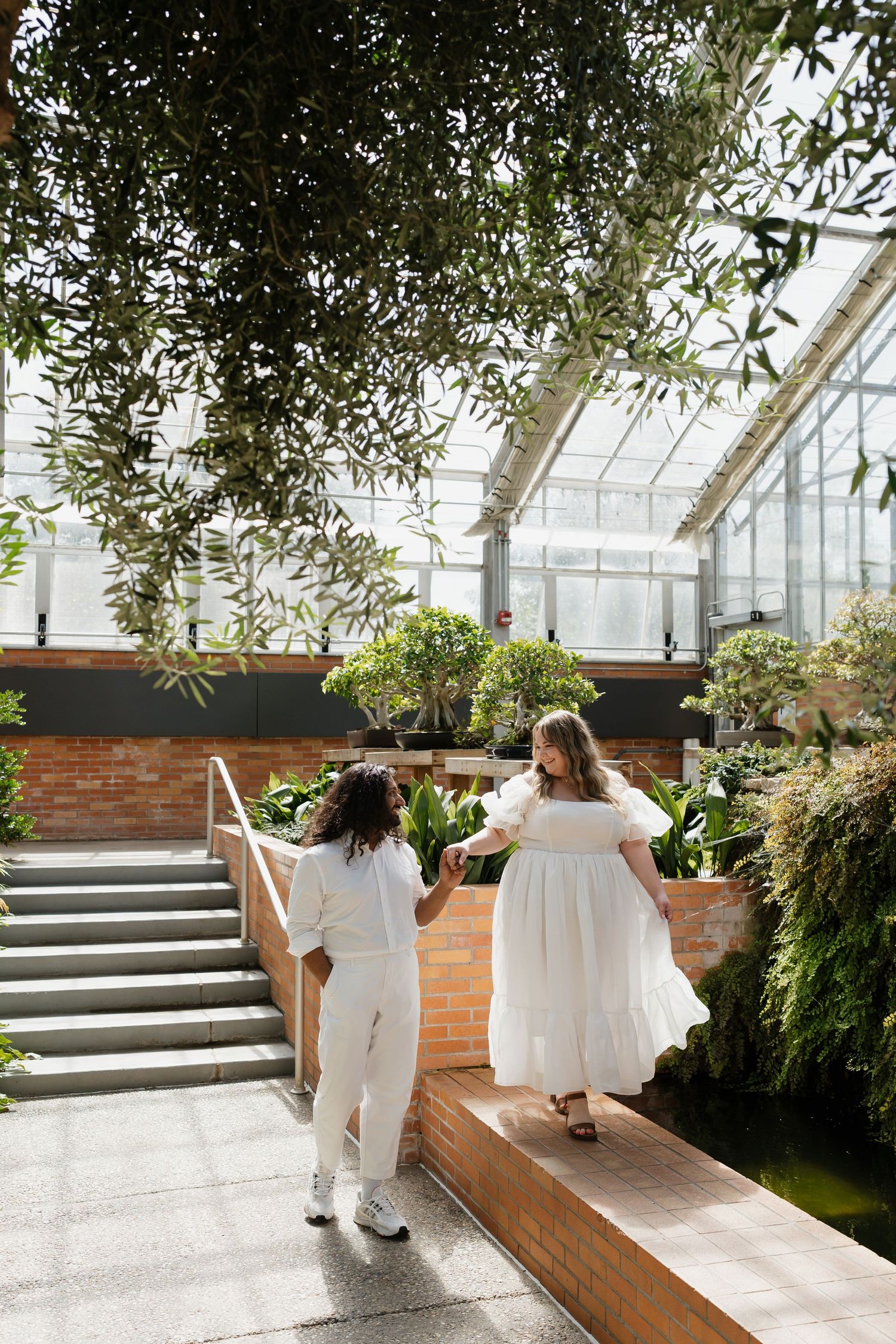 Engaged couple walking through the conservatory at the University of Michigan Matthaei Botanical Gardens