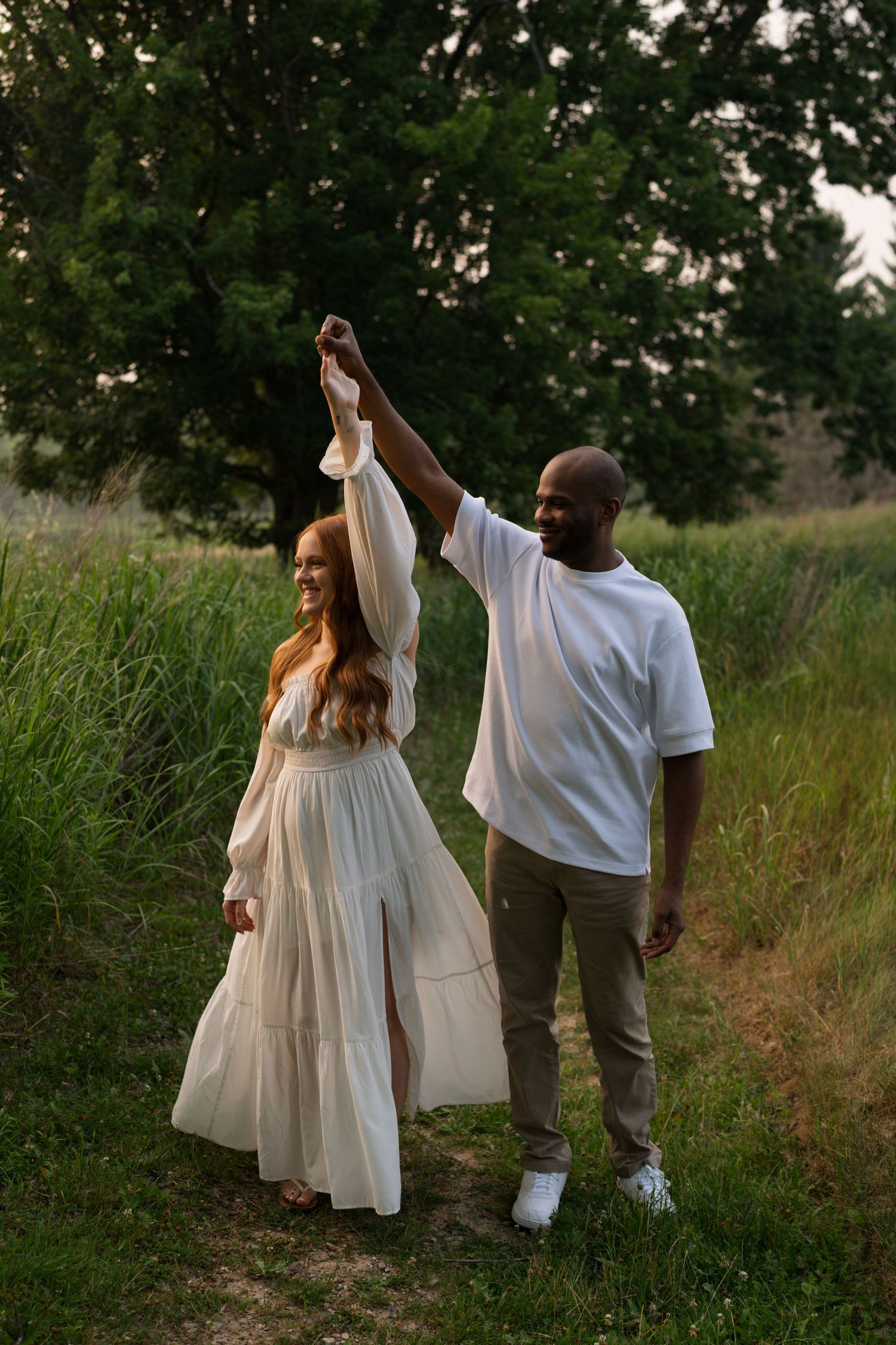 Expectant parents walking hand in hand through Highlands Prairie during their maternity session.