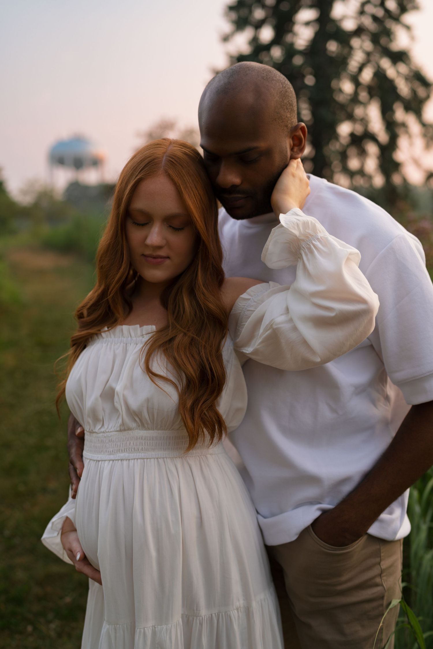 Expectant parents embracing during a maternity session at Highlands Prairie.