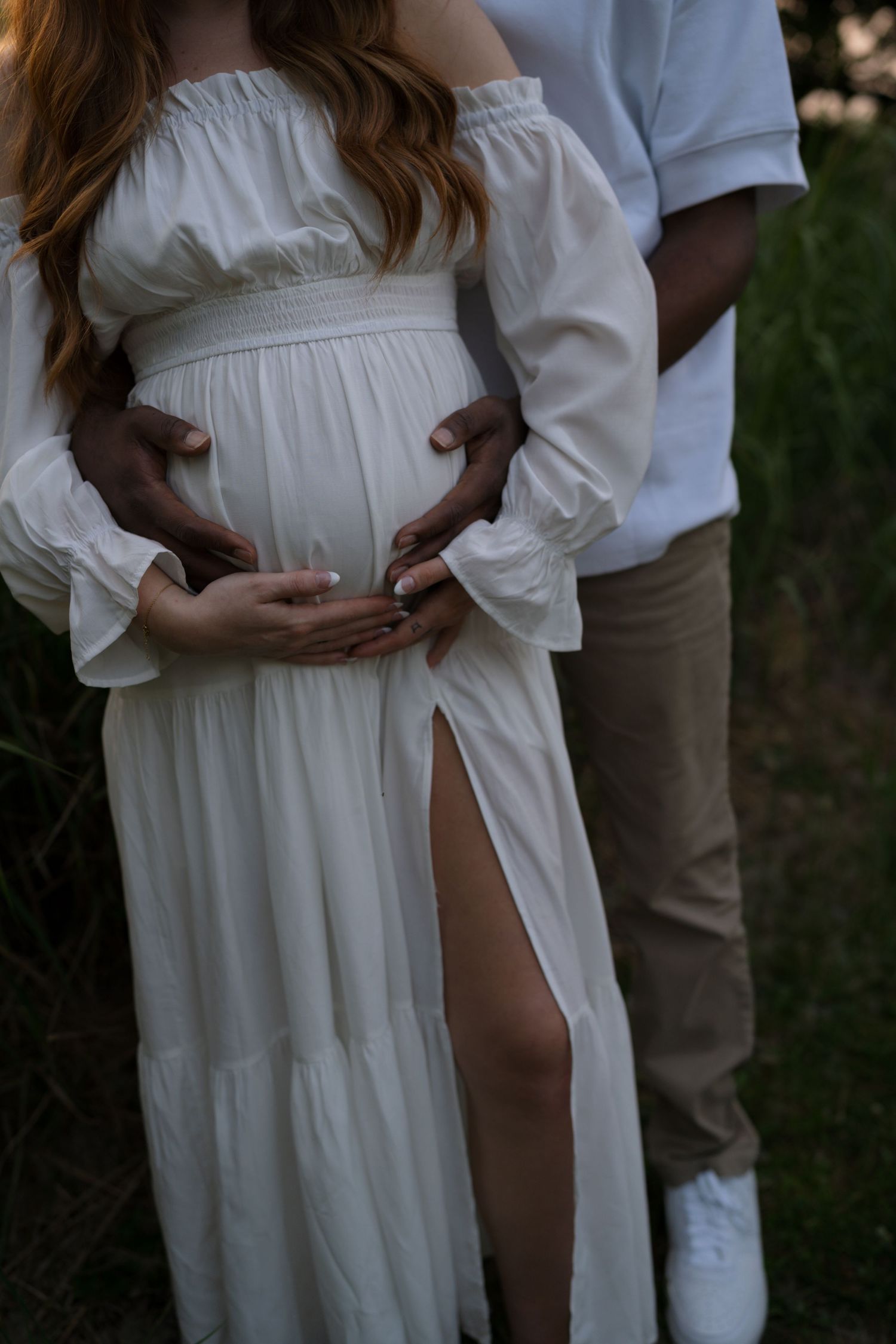 Expectant mother smiling beside her partner during a maternity session at Highlands Prairie.