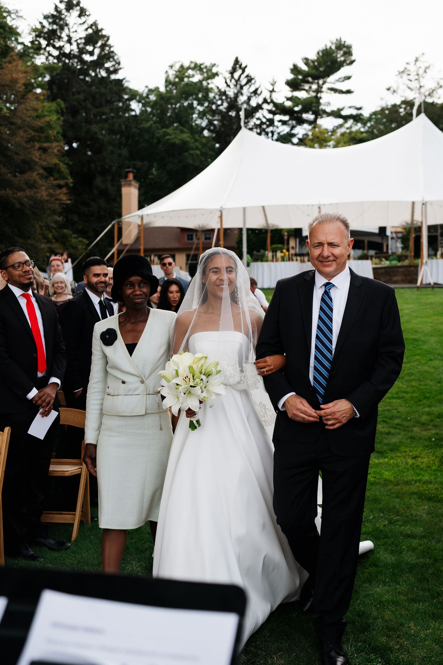 Bride laughing with loved ones during an outdoor wedding reception in Holland, Michigan.