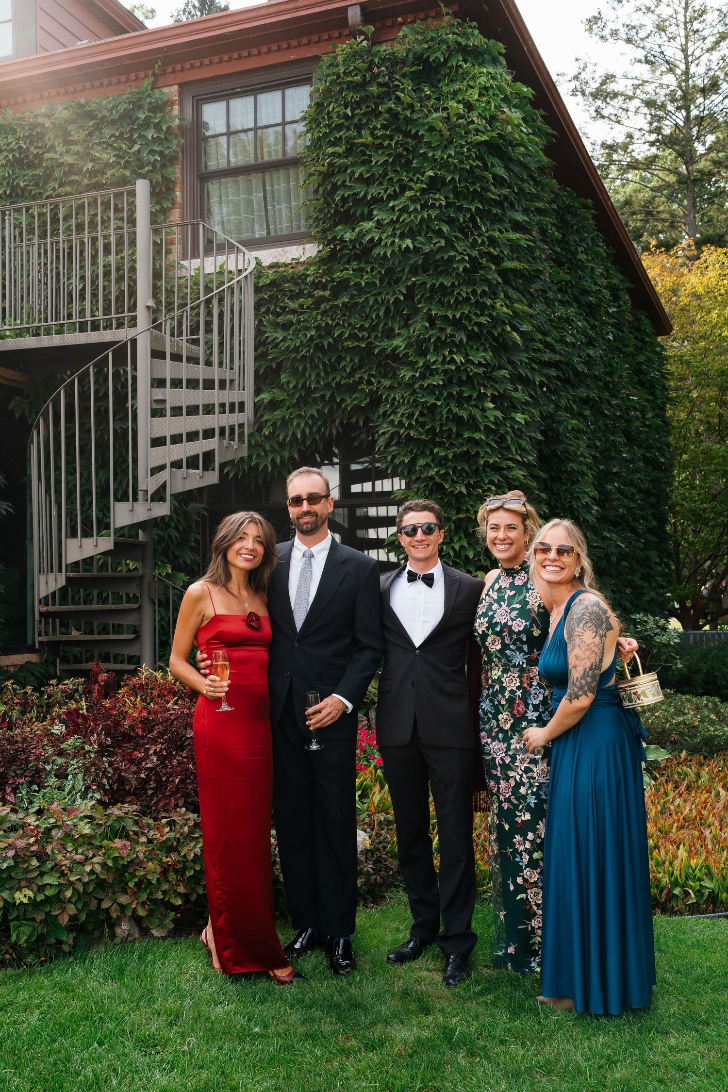 Wedding party posing together outside Marigold Lodge during a wedding celebration in Holland, Michigan.