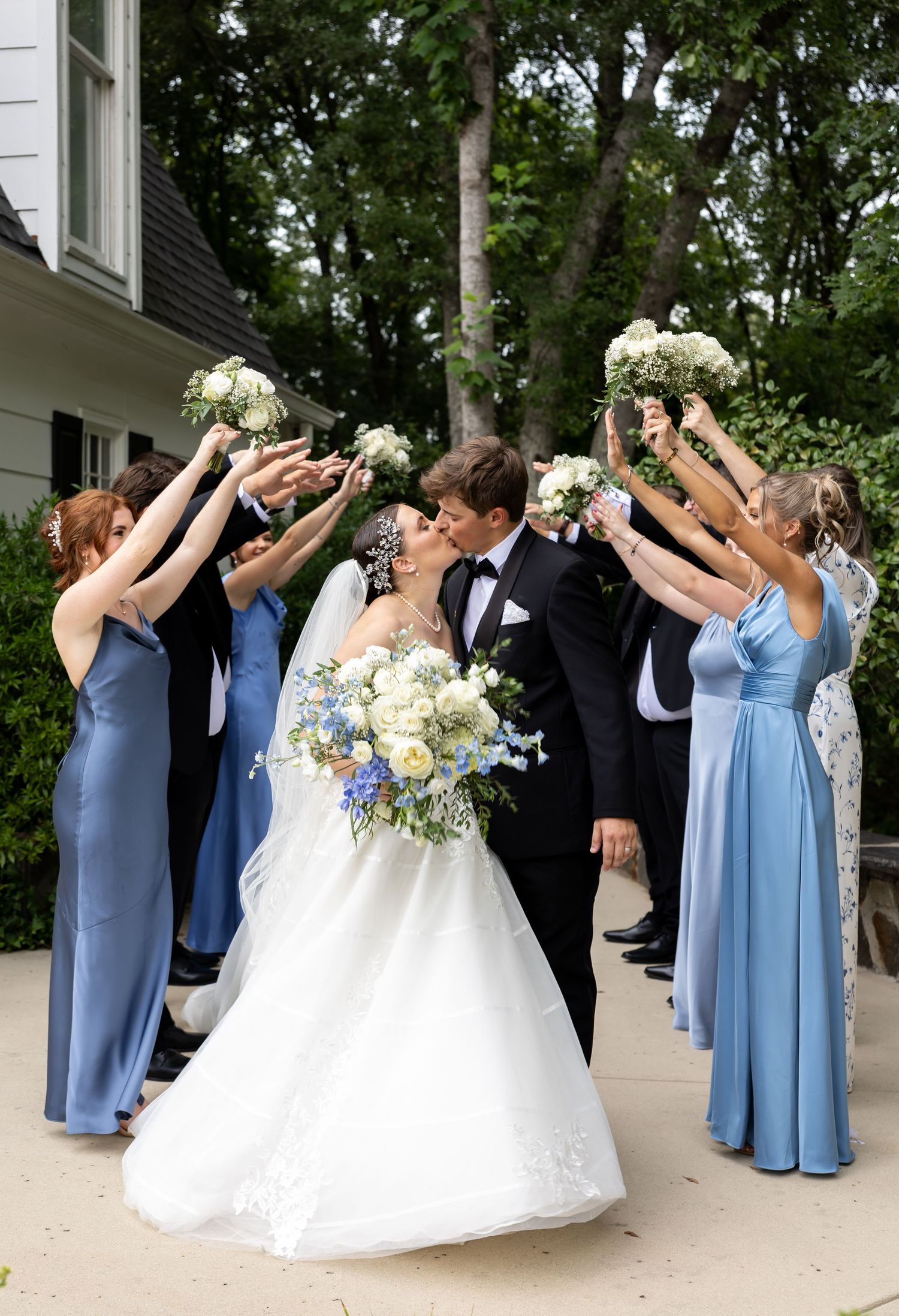Photo of wedding party cheering and bride and groom kissing, photo at The Historic Robertson Homestead by Rock Hill Photographer