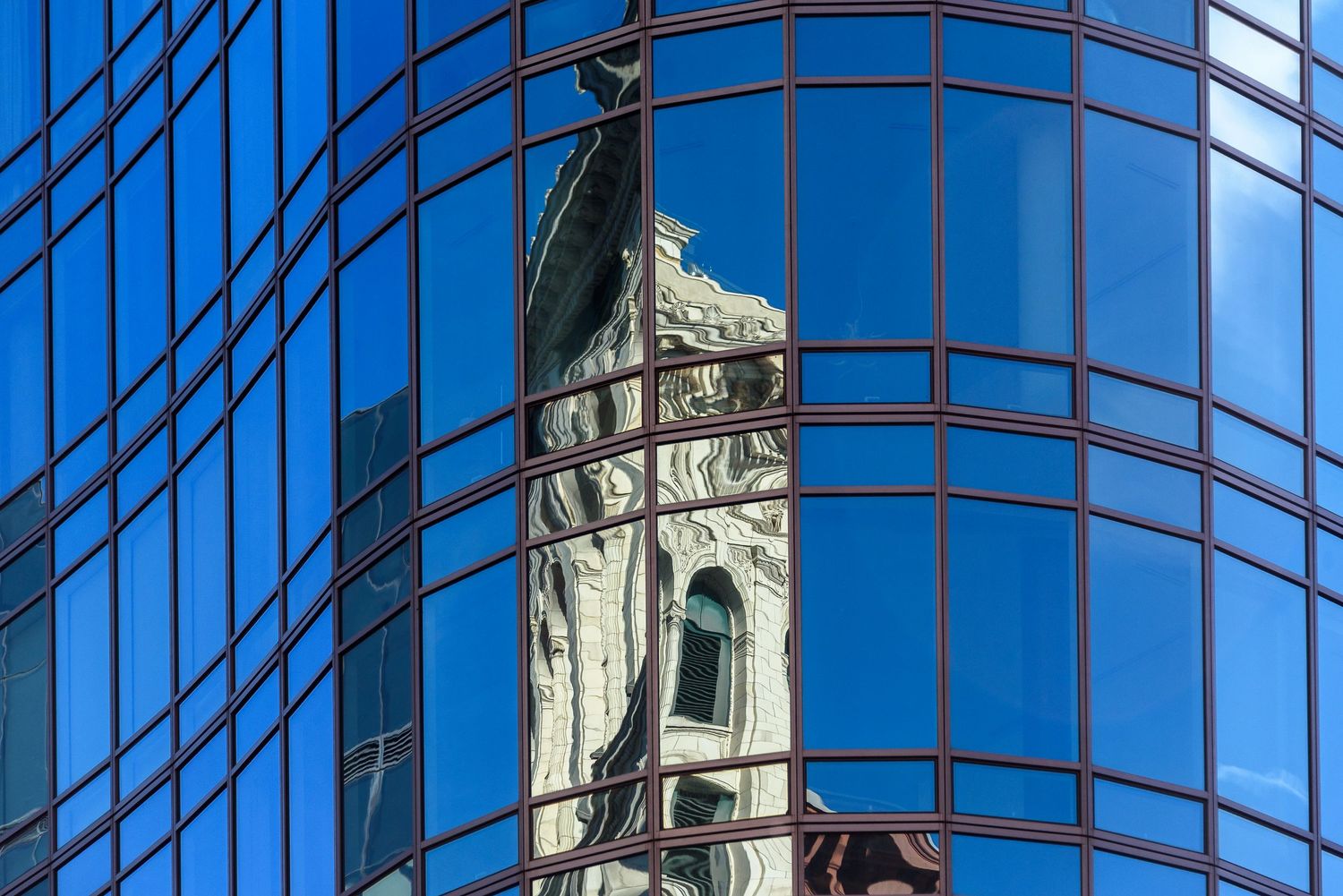 New York reflections - an older building reflected in the glass wall of a modern building