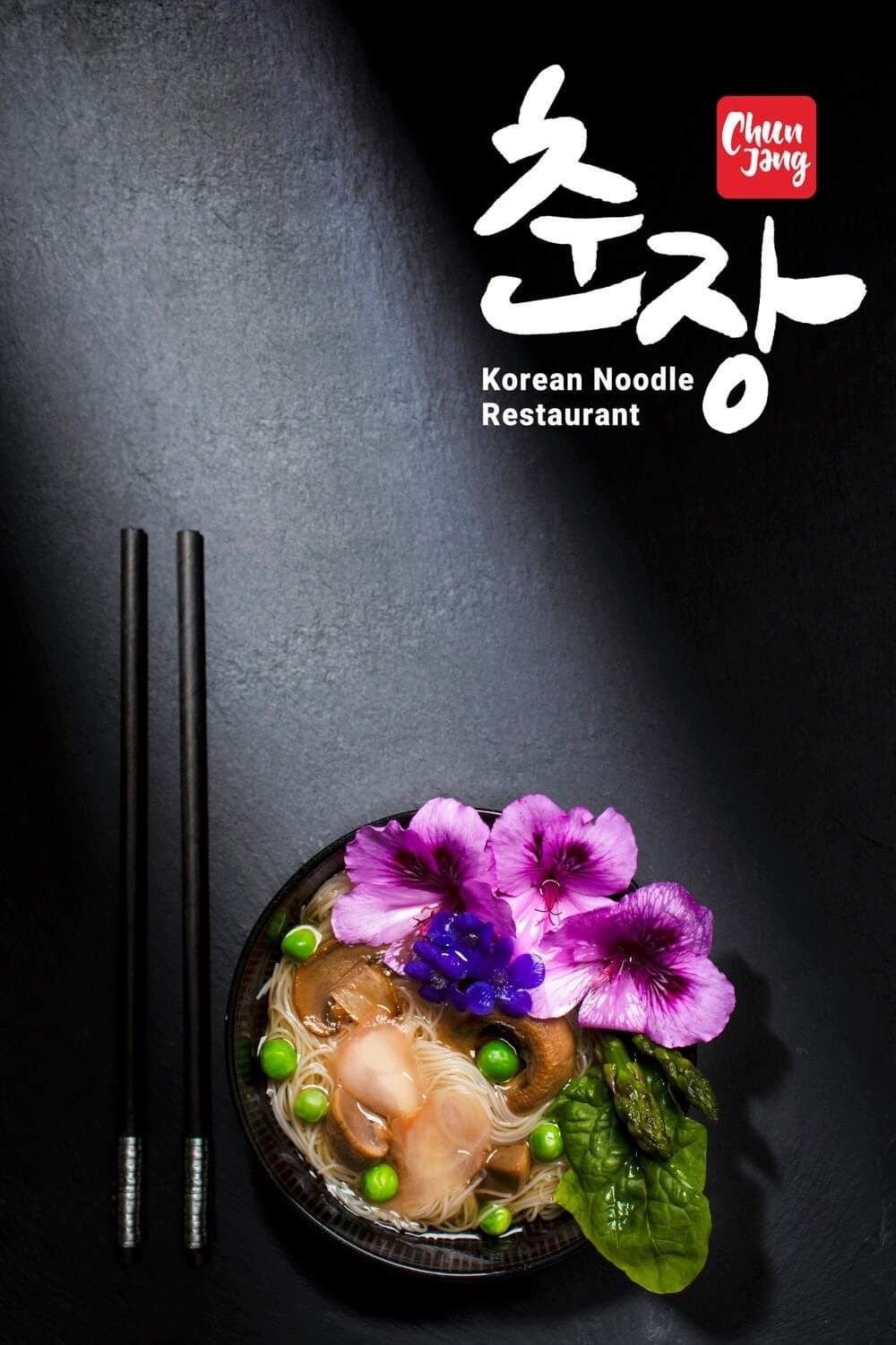 Korean noodle bowl with purple flowers and chopsticks on dark background for Cheon Jong restaurant.