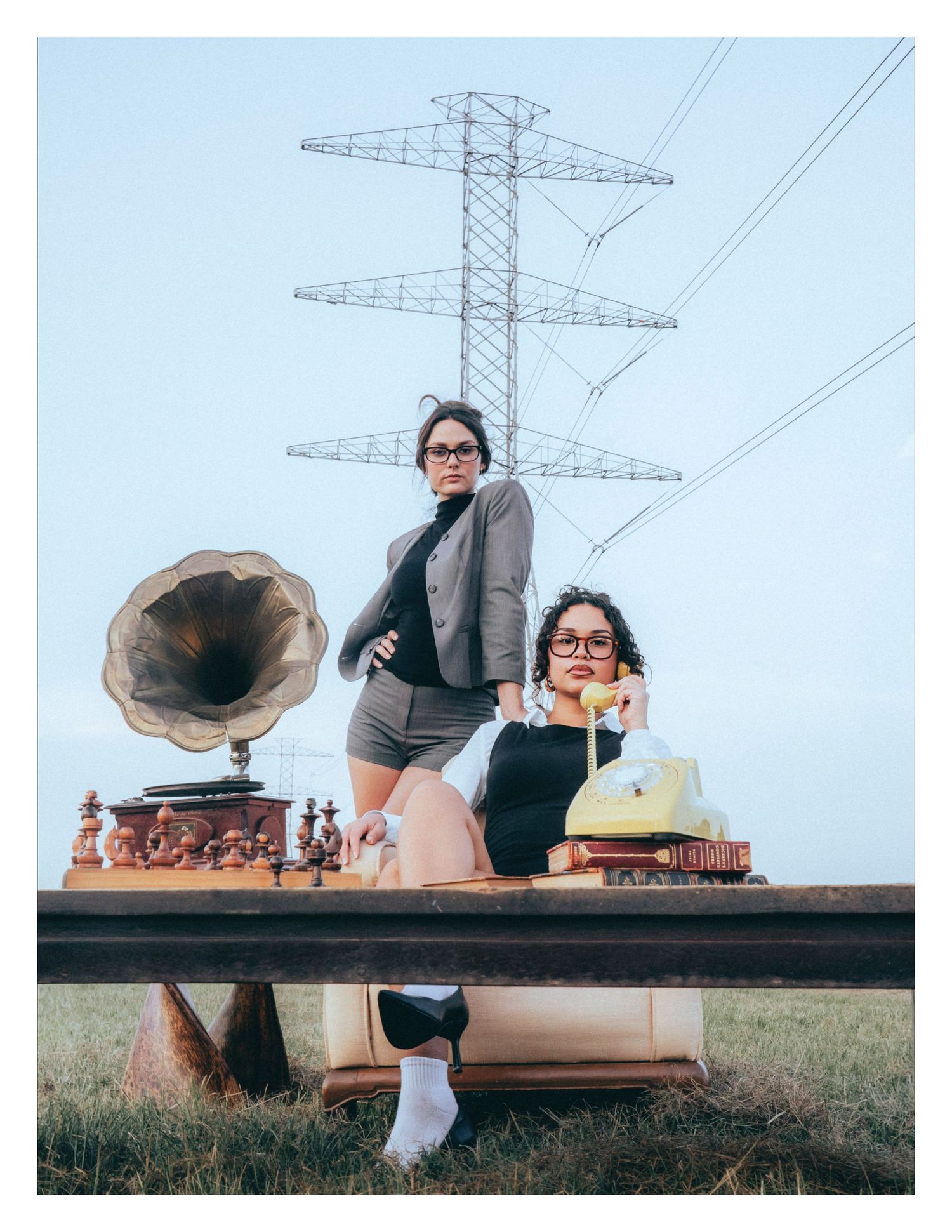 Vintage gramophone and retro items displayed on wooden beam outdoors with electrical tower in background.