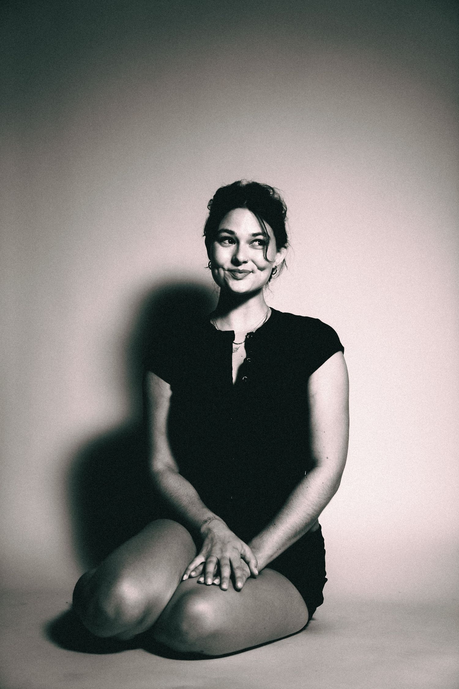 A series of black and white artistic portraits showing a figure in various seated poses against a light background.