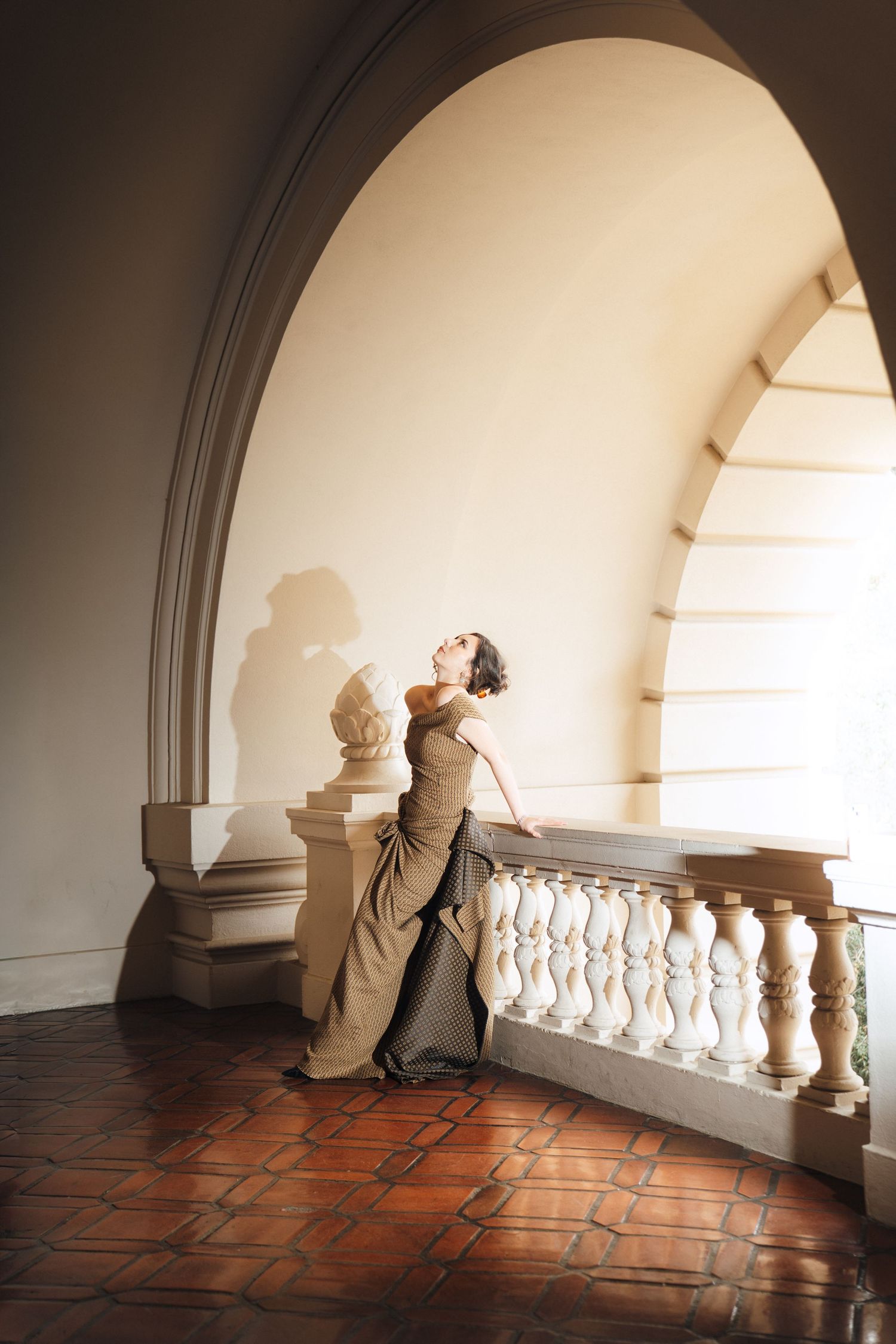 A sequence of photos showing a person in white leaning progressively further back against a railing in an arched hallway.