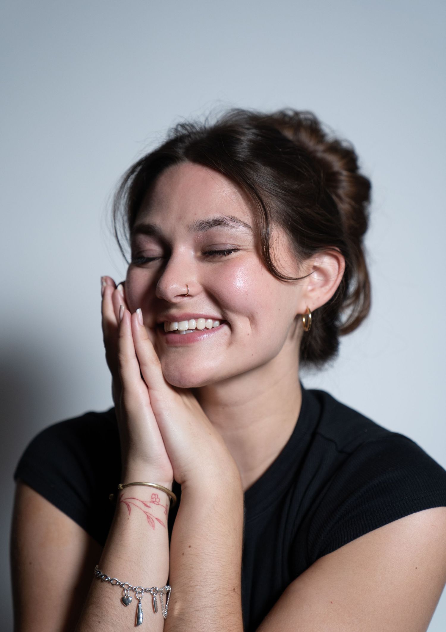 A sequence of photos showing someone in a black top expressing joy and laughter while covering their face with their hands.
