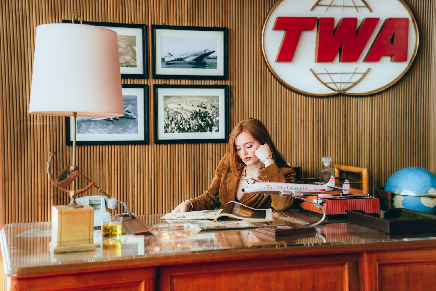 Vintage TWA airline office interior with wood paneling, aviation memorabilia and retro furnishings from the mid-century era.