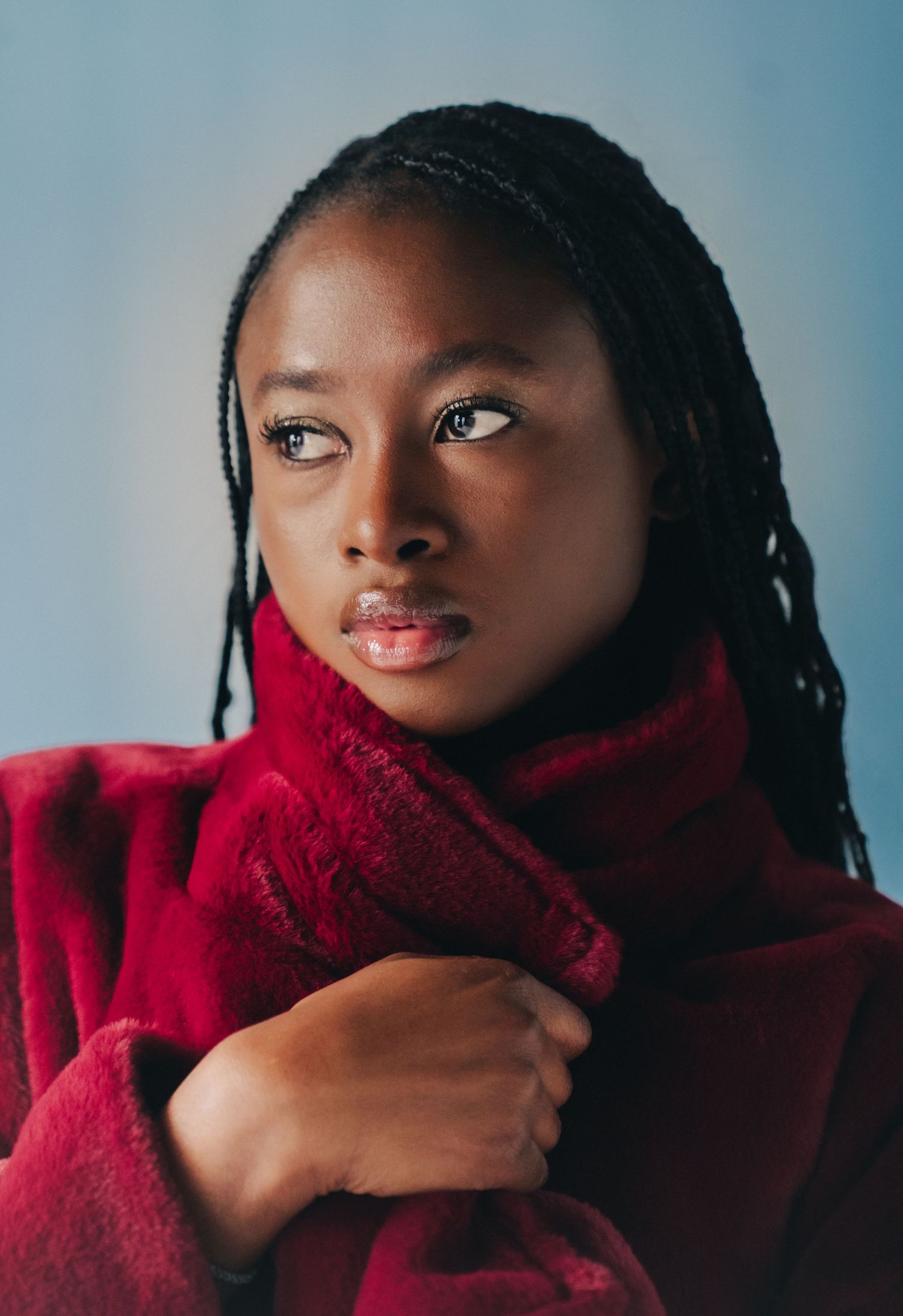 A series of artistic portraits showing someone wearing a vibrant red turtleneck sweater against a blue background.