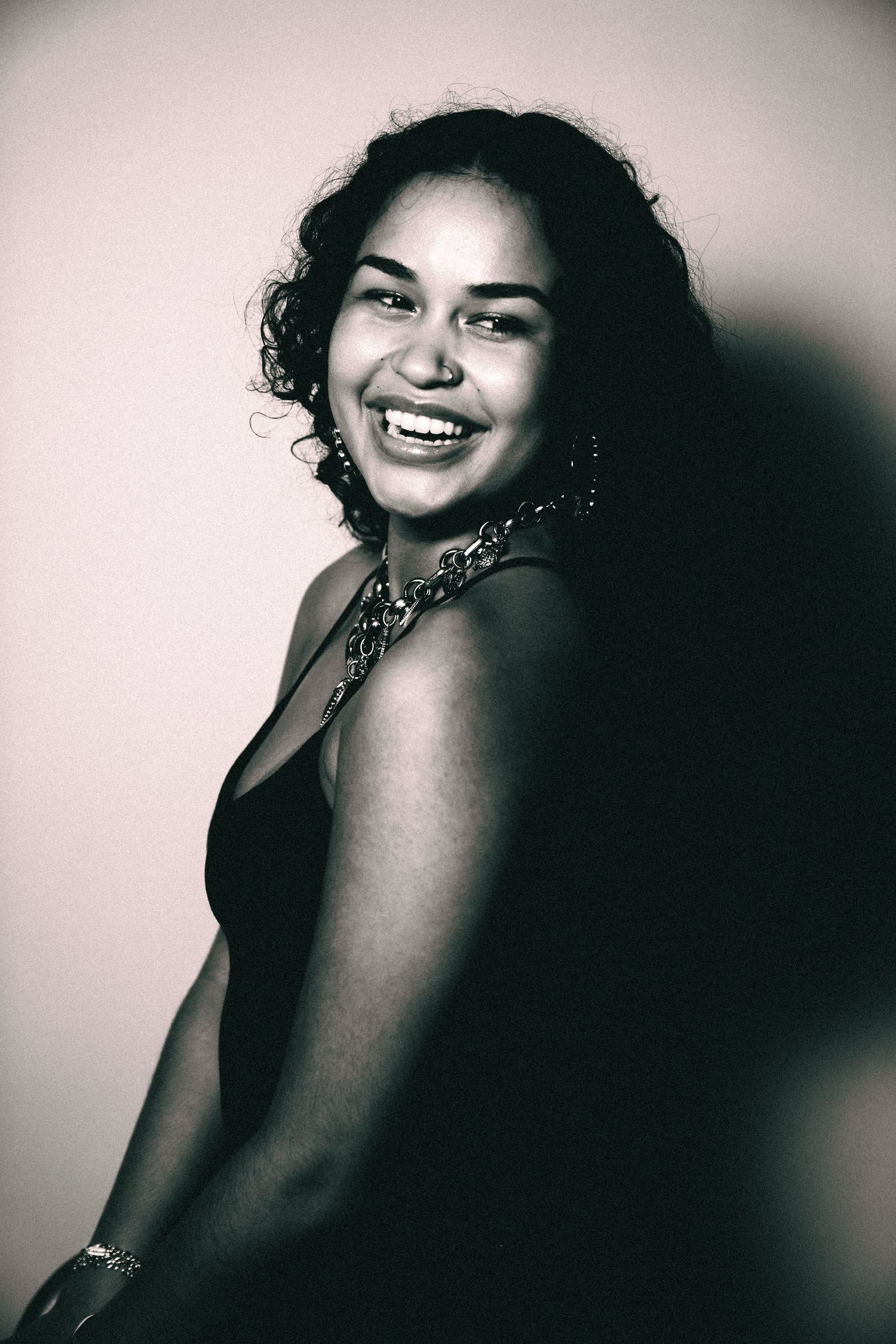 Black and white portrait series showing a person in dramatic lighting with expressive poses and genuine smiles.