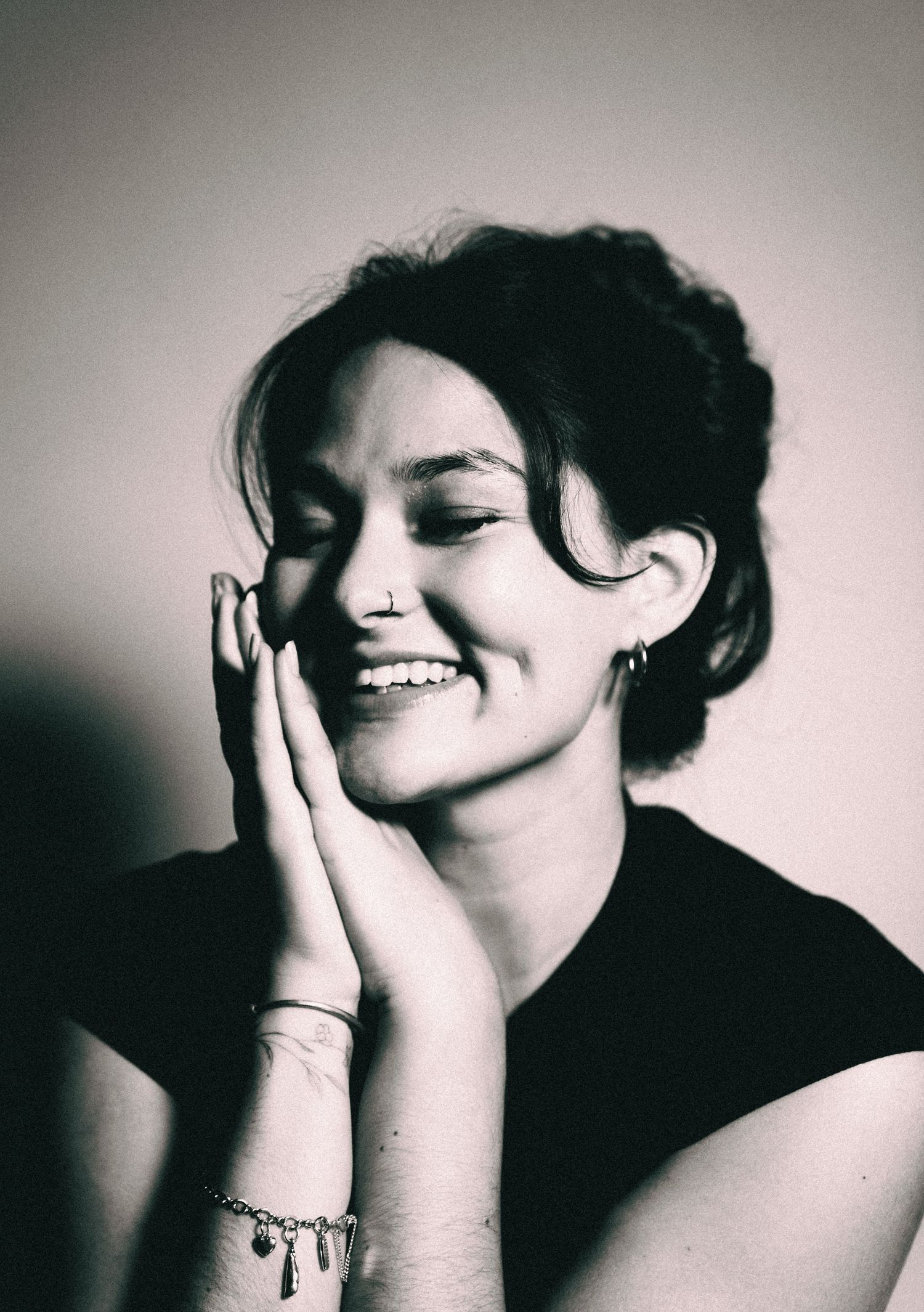 A series of black and white artistic portraits showing emotional expressions and hand gestures against a simple background.