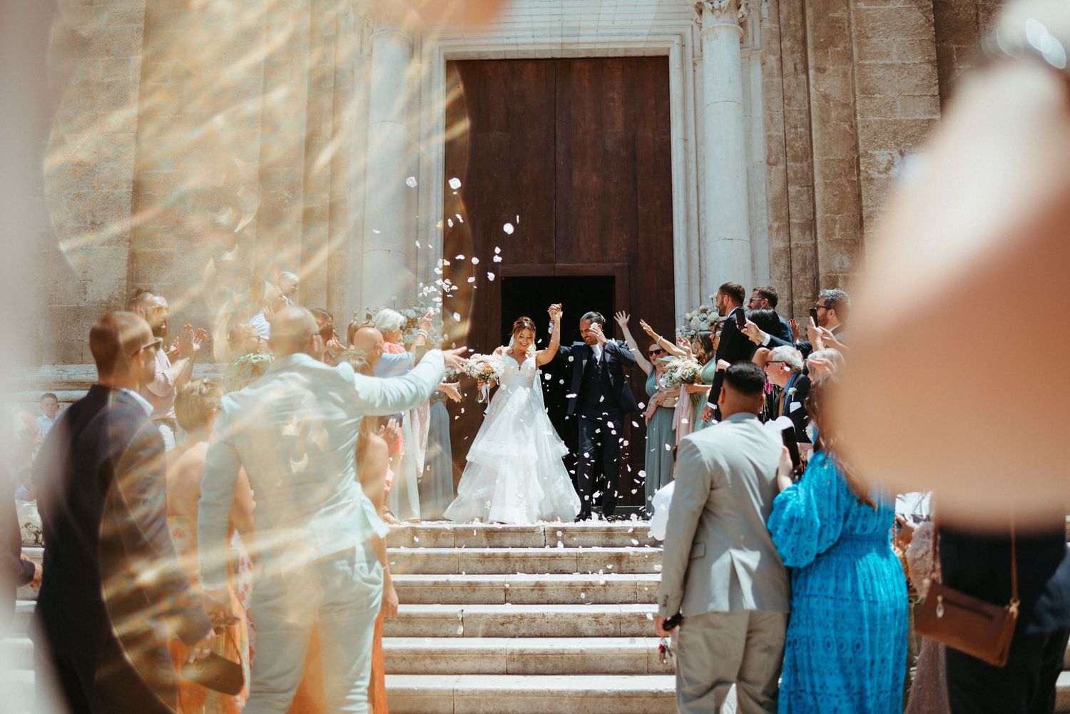 Wedding celebration with confetti being thrown on church steps.