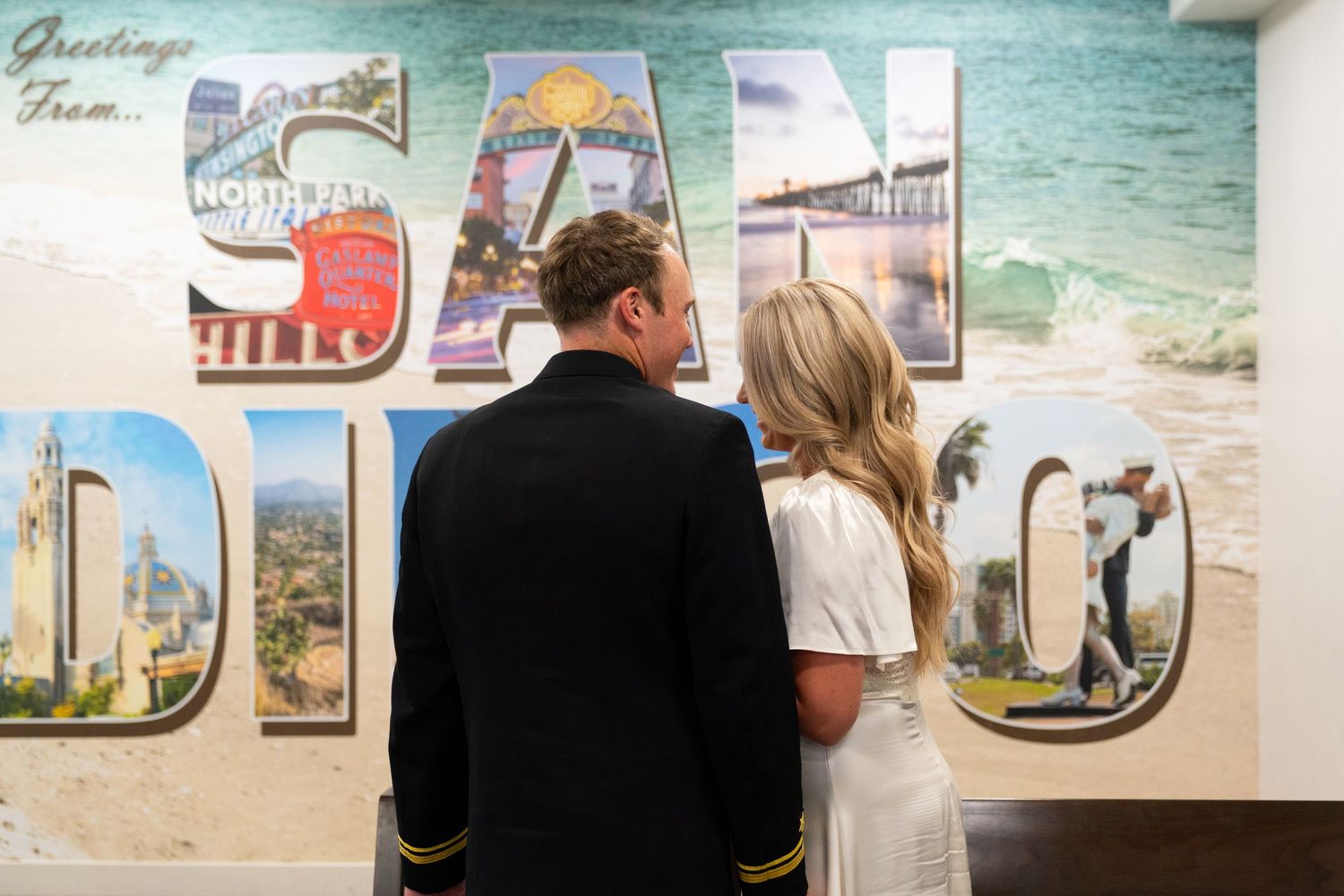 People examine a multi-letter museum display spelling out 'CLT' with vintage local landmark photos incorporated.