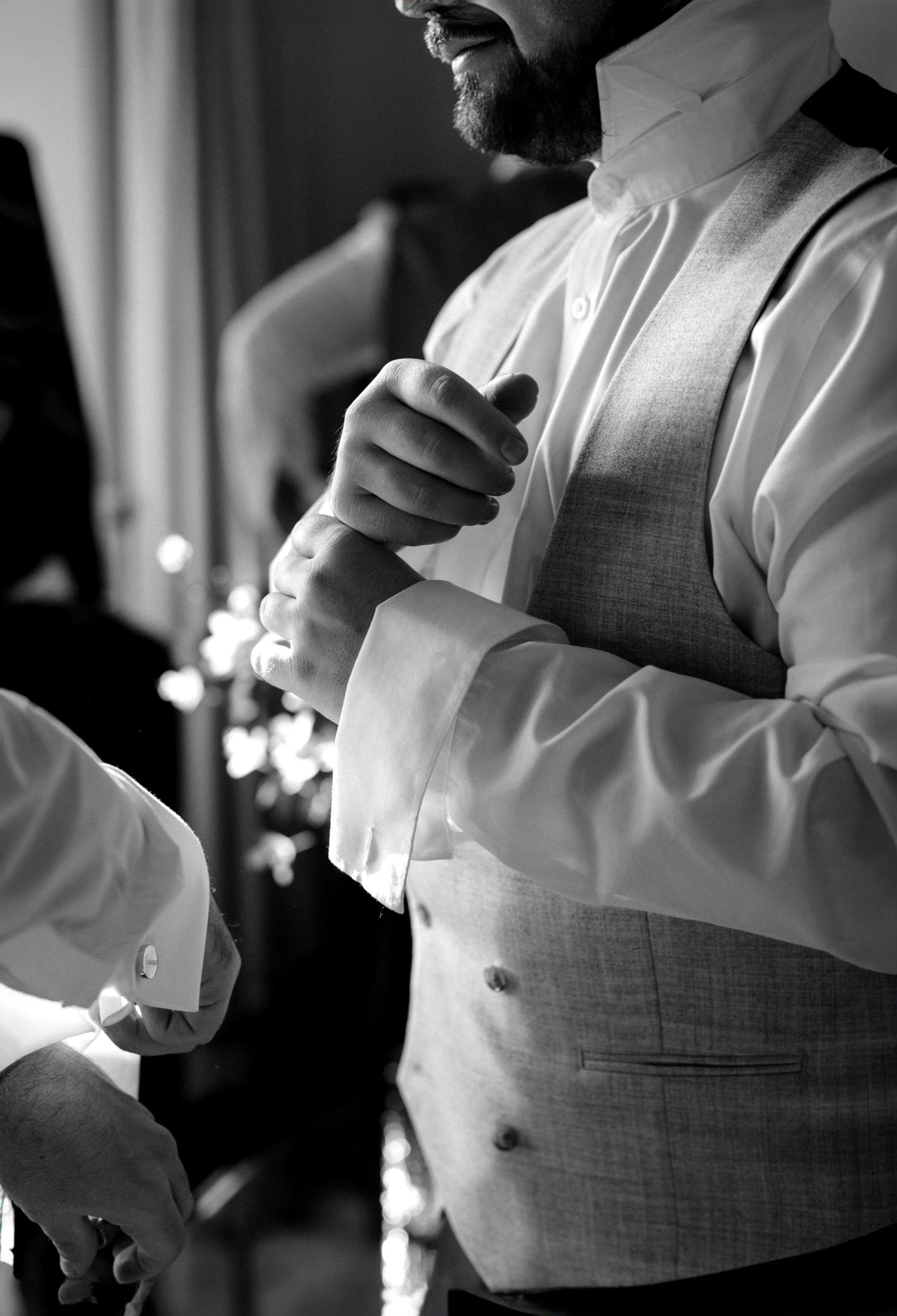 groom putting on cufflinks