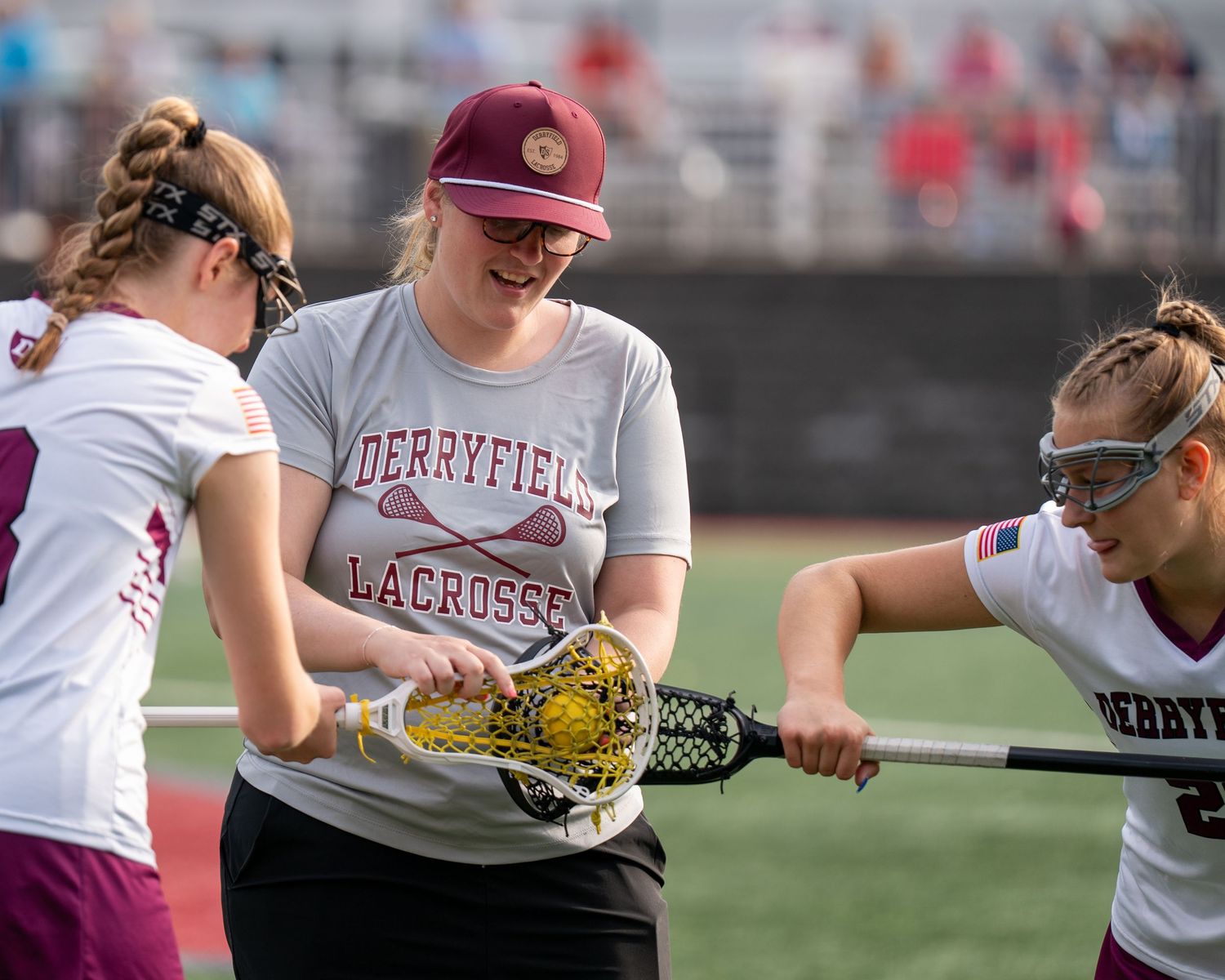 Derryfield New Hampshire Women's lacrosse coach Margo Teeters  helps her lax players perfect their form in sports photography before a game