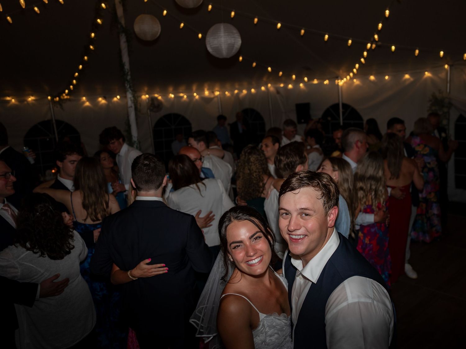 Photography of bride and groom sharing a moment with friends and family after an elegant New England wedding ceremony in New Hampshire.