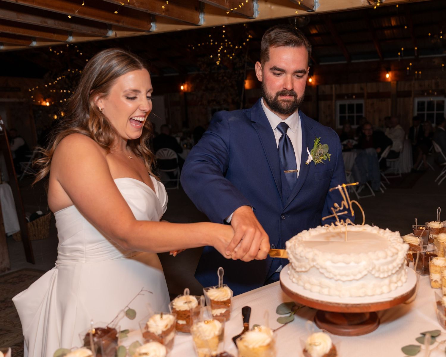 Photography bride and groom share a fun  cake cutting moment after an elegant New England wedding ceremony celebration in New Hampshire