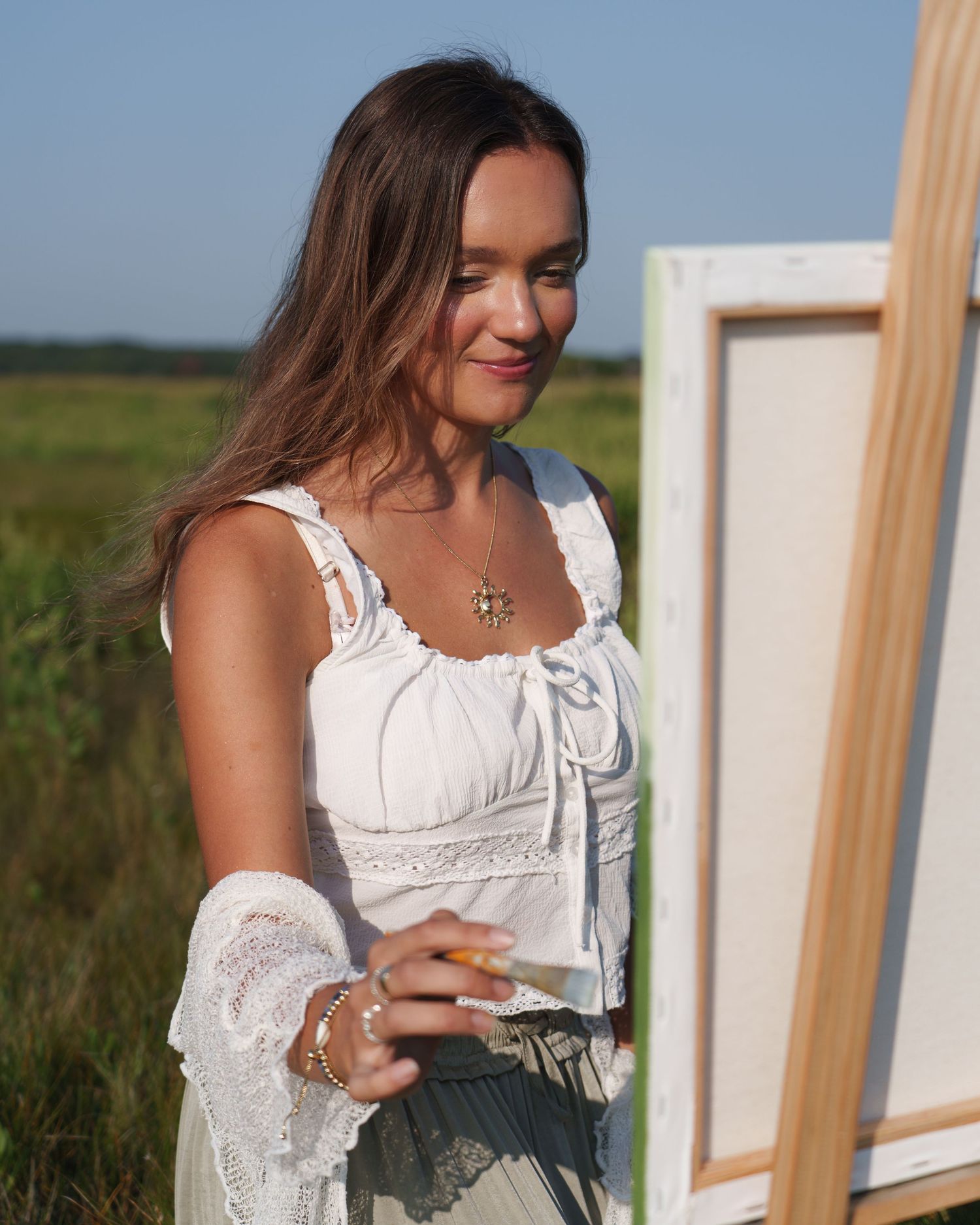 New England artist Rachel Marie Artistry painting during a branding photography session to showcase her art on a beautiful fall golden hour.