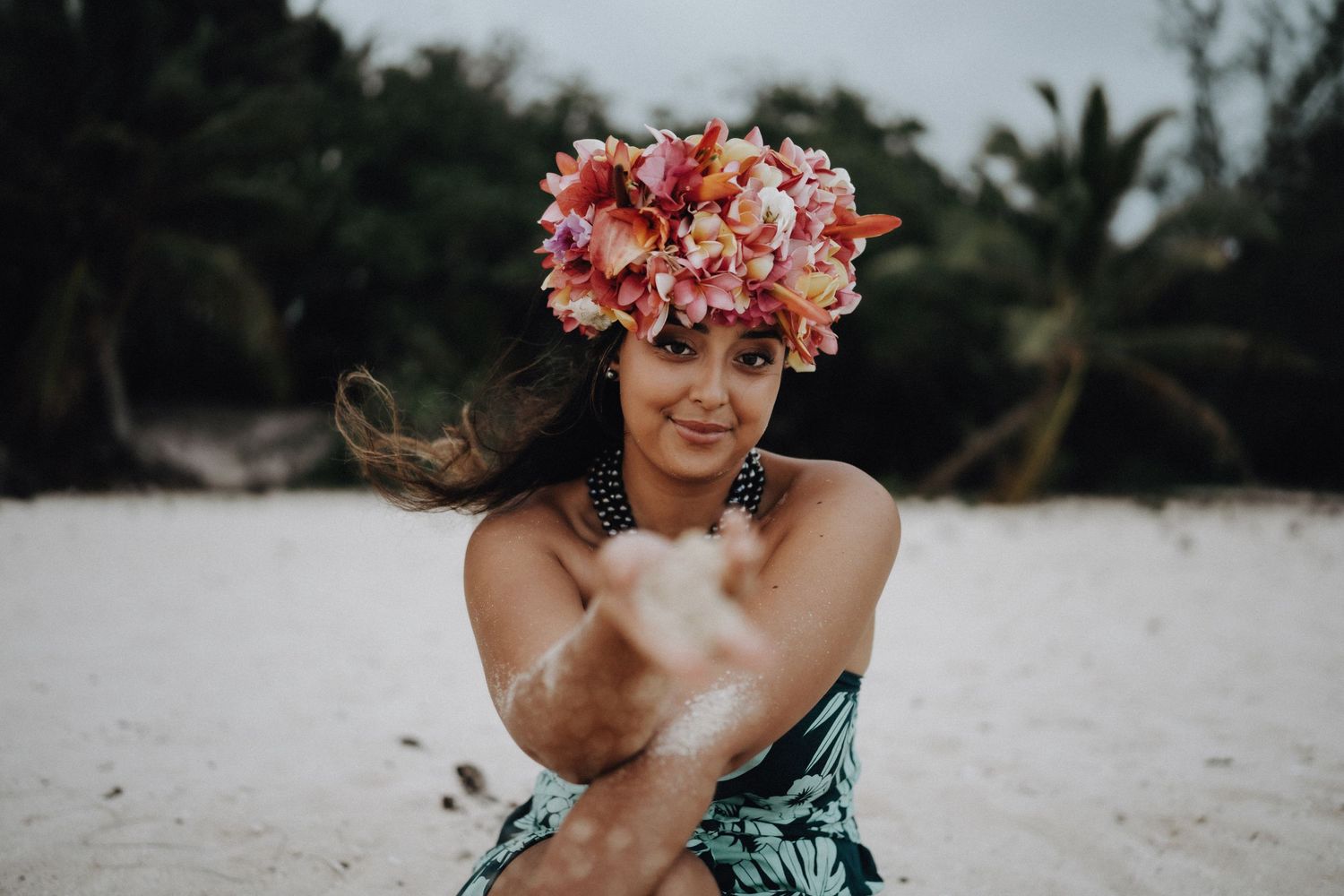 Playful beach portrait with pink floral crown and tropical print dress.