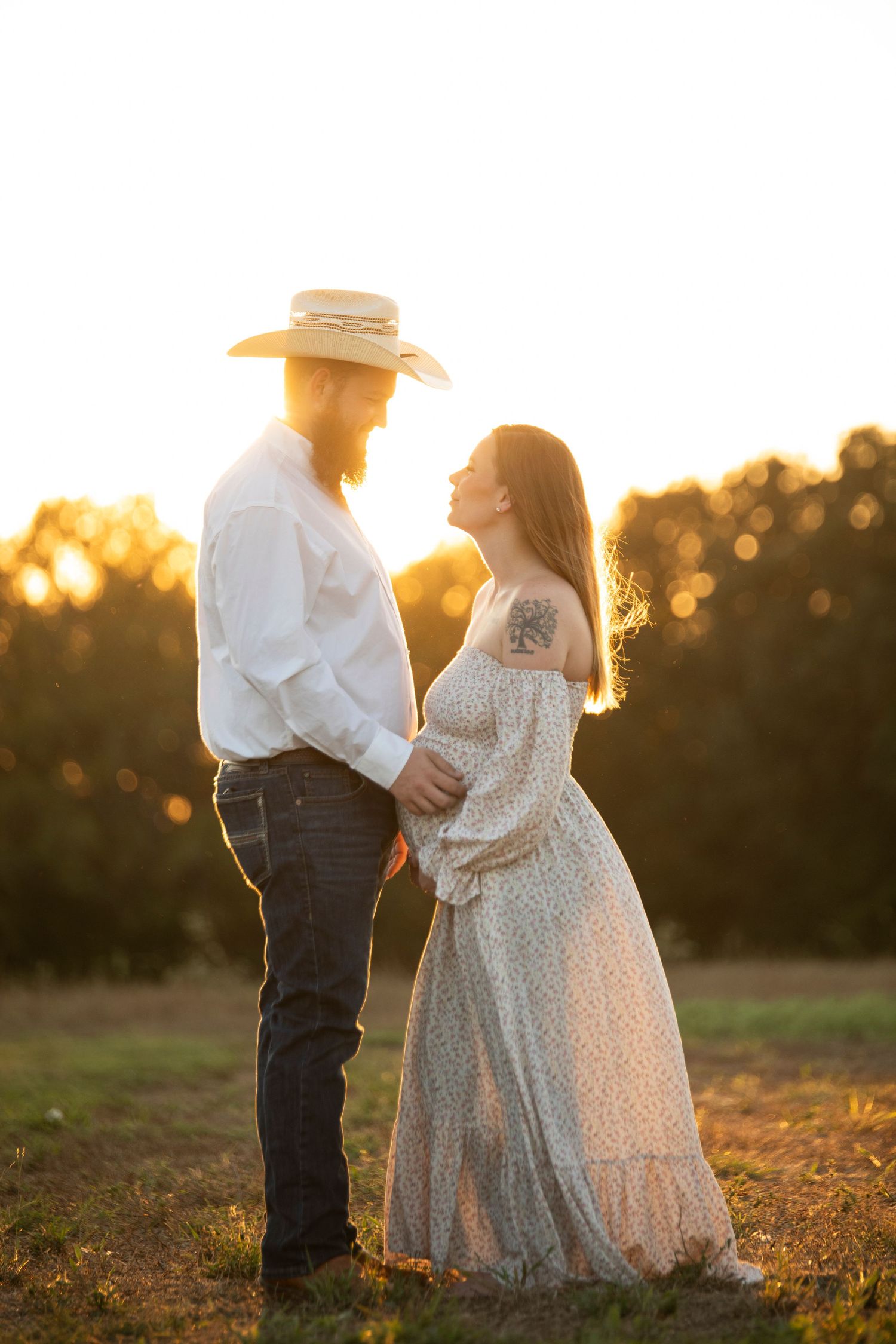 Sulphur Springs maternity photographer, man and women standing in field at sunset.