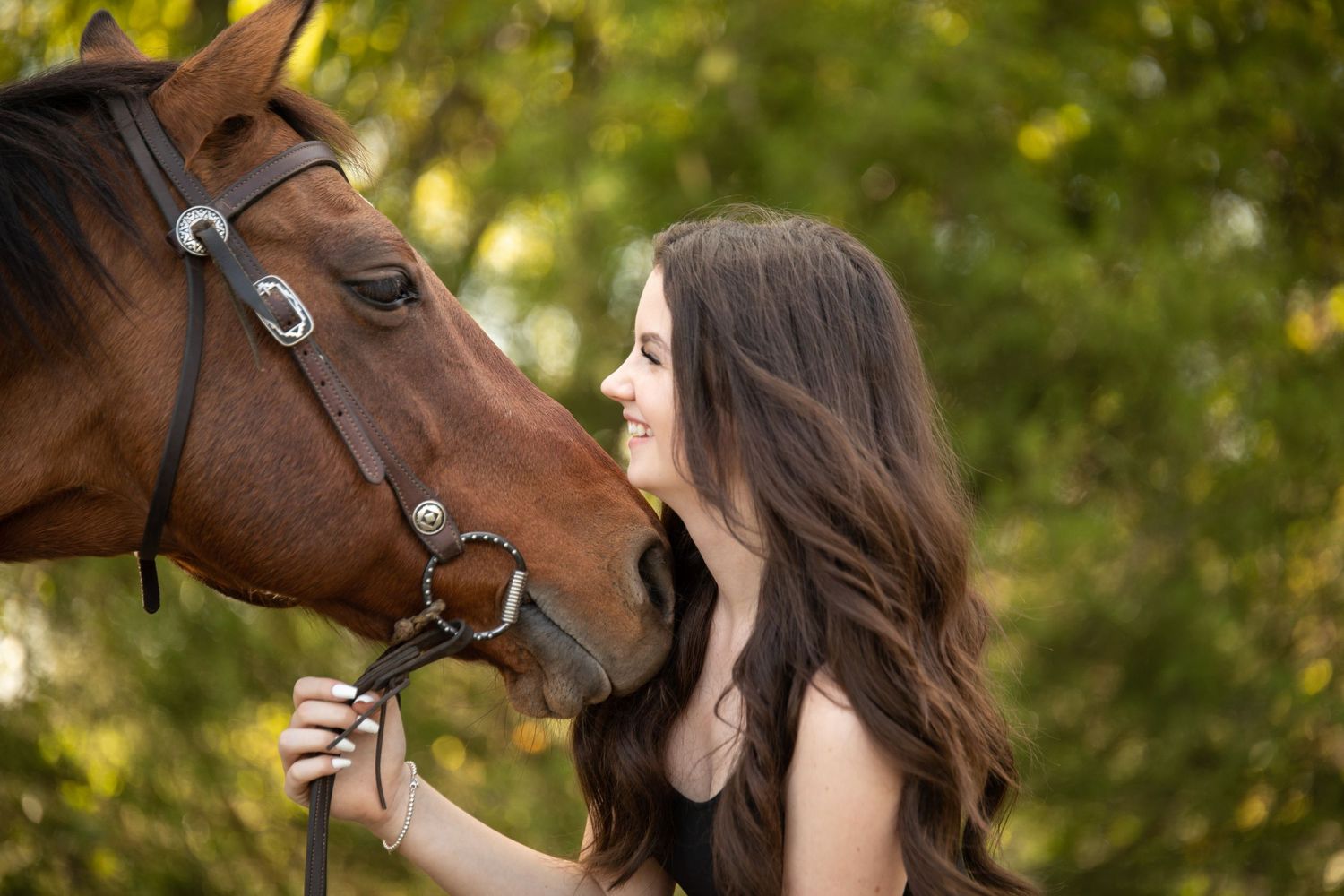 girl smiling while horse nuzzles her neck. equine photography.