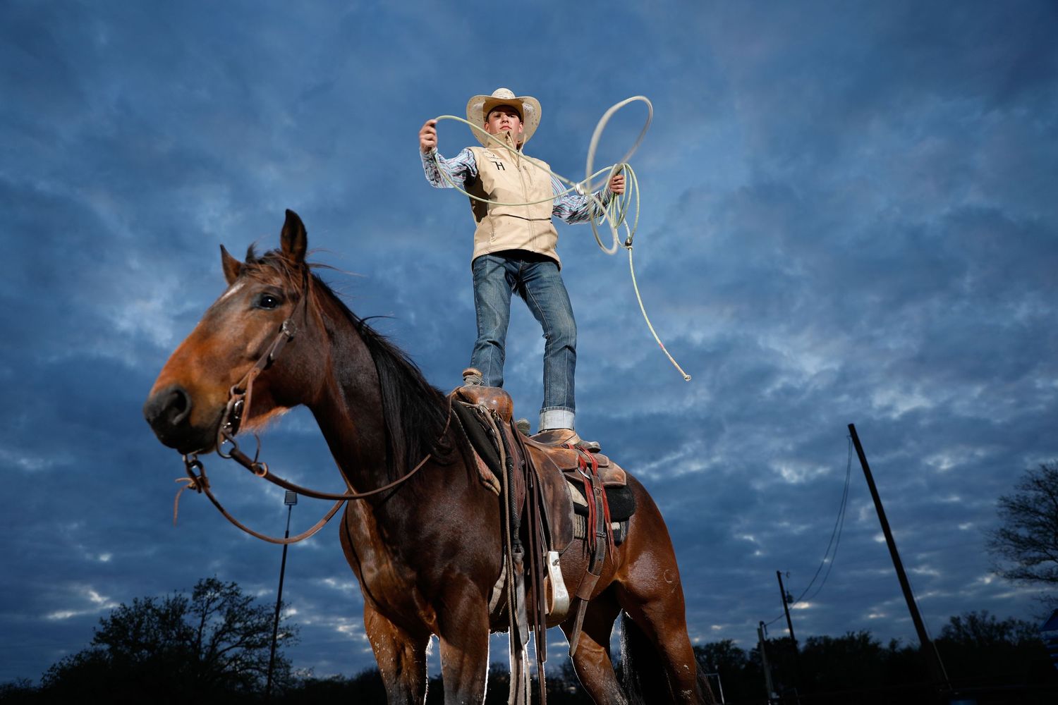 man standing on horseback while throwing a lasso. Dallas equine photographer.