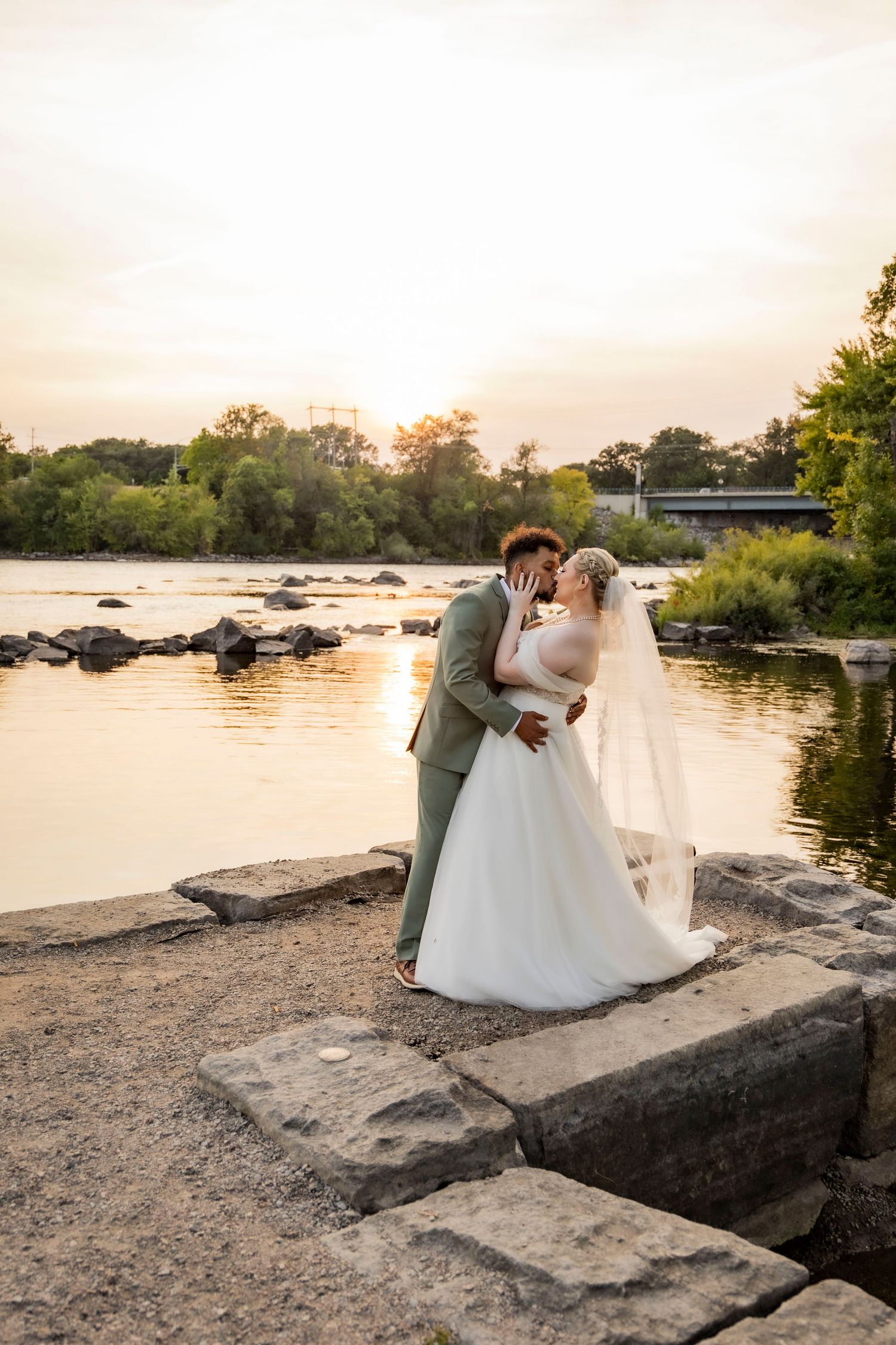 Newlyweds kissing by the lake in Saux Rapids, Minnesota at The Clearing wedding venue
