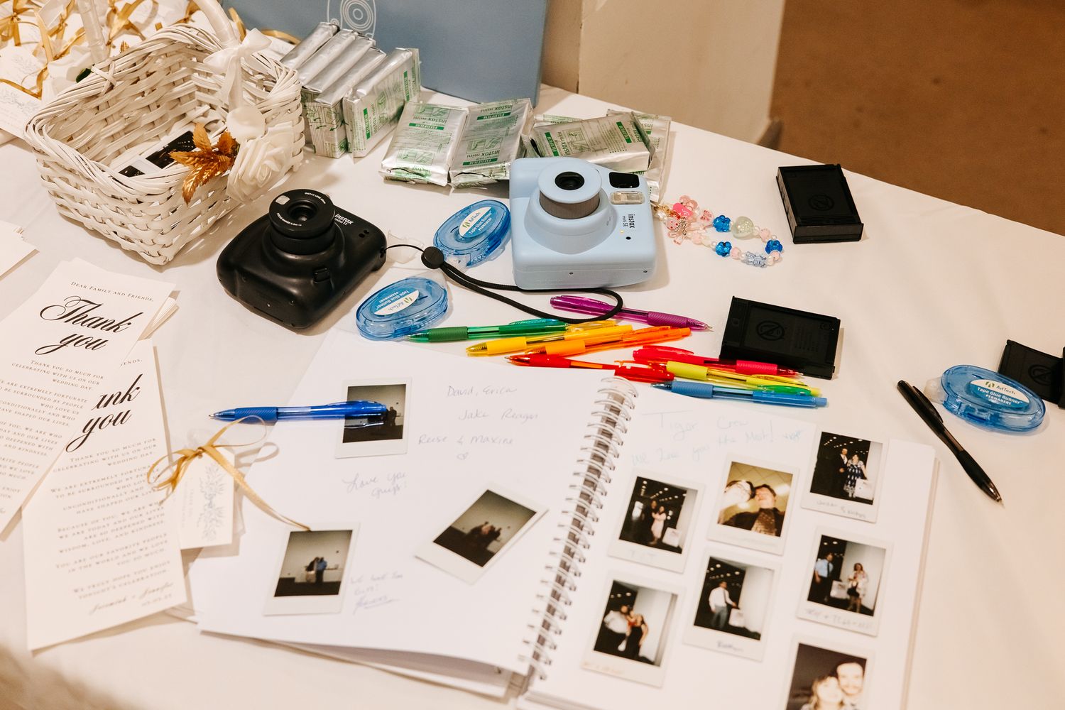 Scrapbooking supplies and photos spread out on a wooden table with scissors and craft materials.