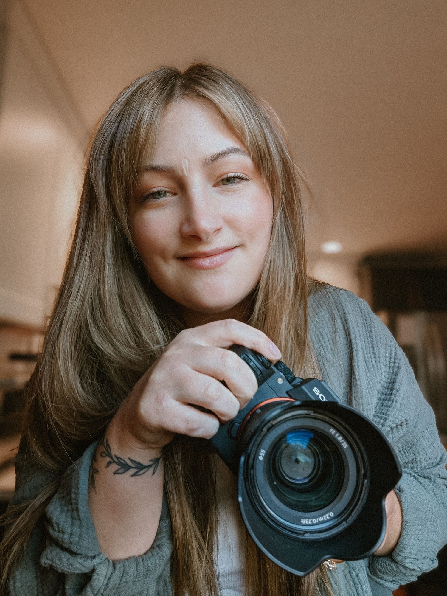 Photographer demonstrating different poses with camera in indoor setting.
