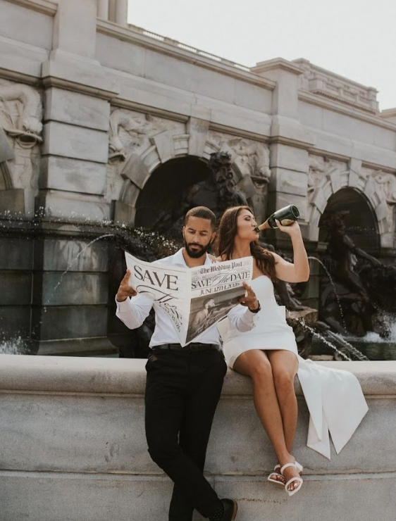 A couple in formal attire playfully poses against a marble building wall in a series of romantic engagement photos.
