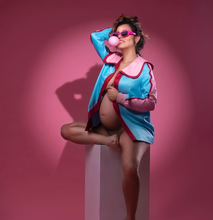 A dance sequence showing graceful movements in a pink-tinted studio setting with blue costume elements.