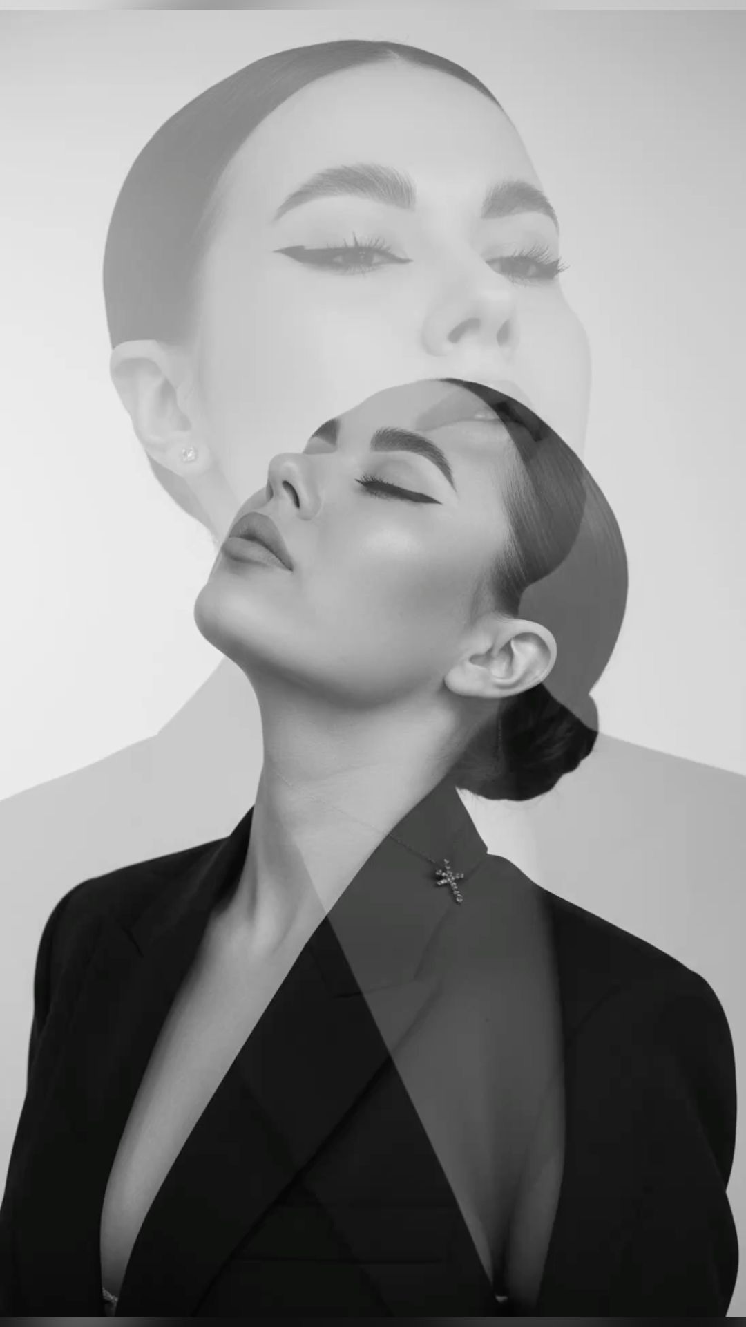 Black and white double exposure portrait of a woman in a black blazer with elegant makeup and hair.