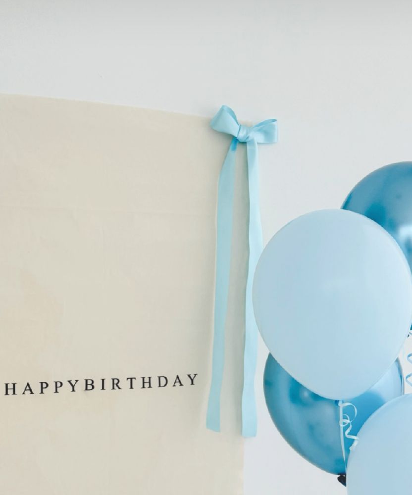 Light blue balloon and ribbon against a white background create a minimalist birthday celebration scene.