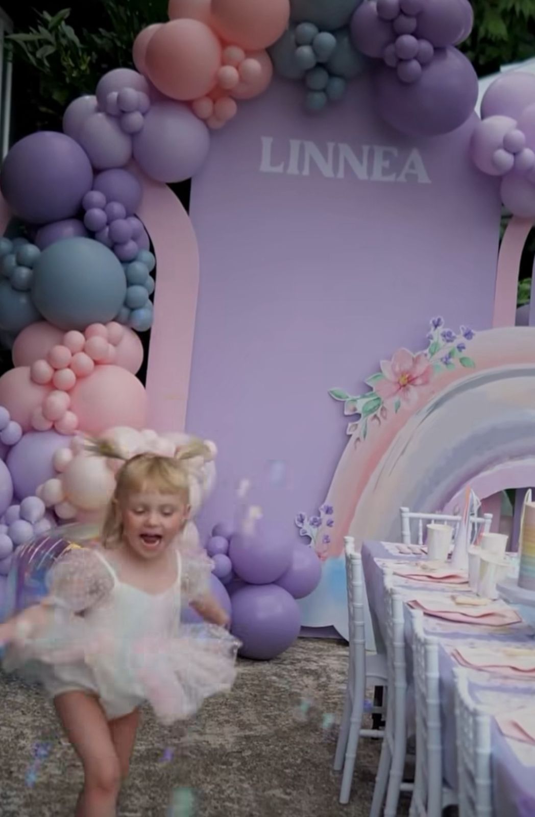 A series of four photos showing a toddler in a tutu twirling and dancing near purple and pink balloon decorations.
