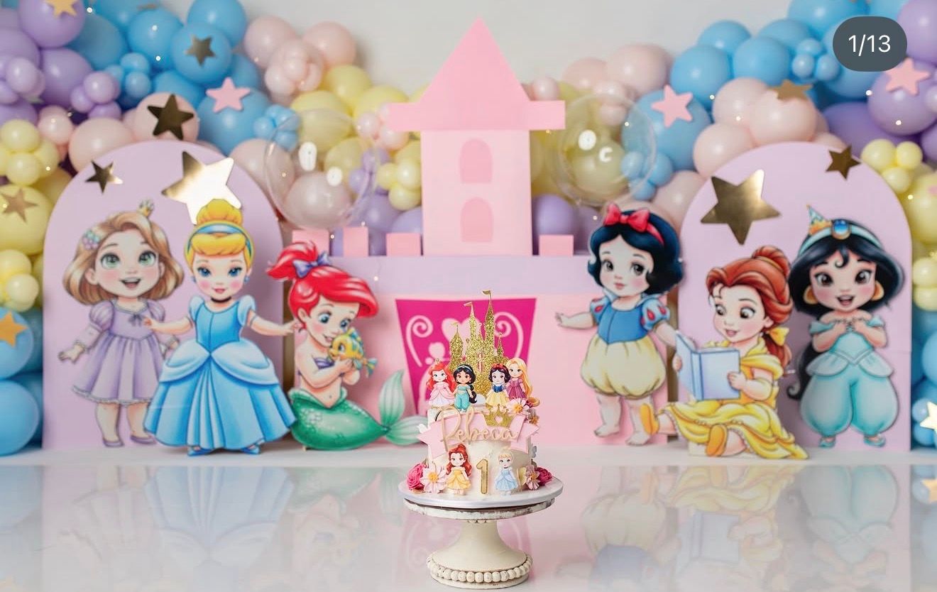 Disney Princess baby shower cake table with Cinderella, Ariel, Snow White, and Jasmine cutouts, balloon arch, and themed cake.