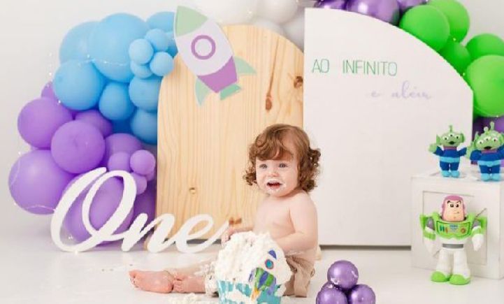 Colorful balloon arch with pastel purple, blue and green balloons decorates a Toy Story themed birthday party setup.