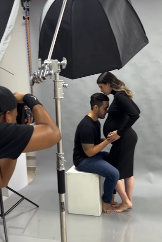 Behind-the-scenes photography setup showing lighting equipment and studio backdrop preparation.