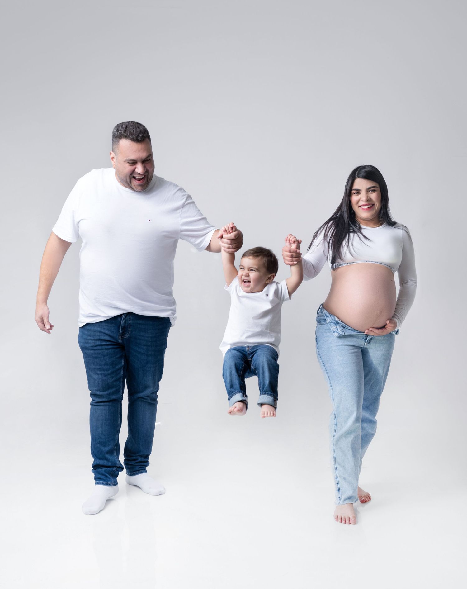 Series of progressive images showing a baby learning to walk with adult support against white background.