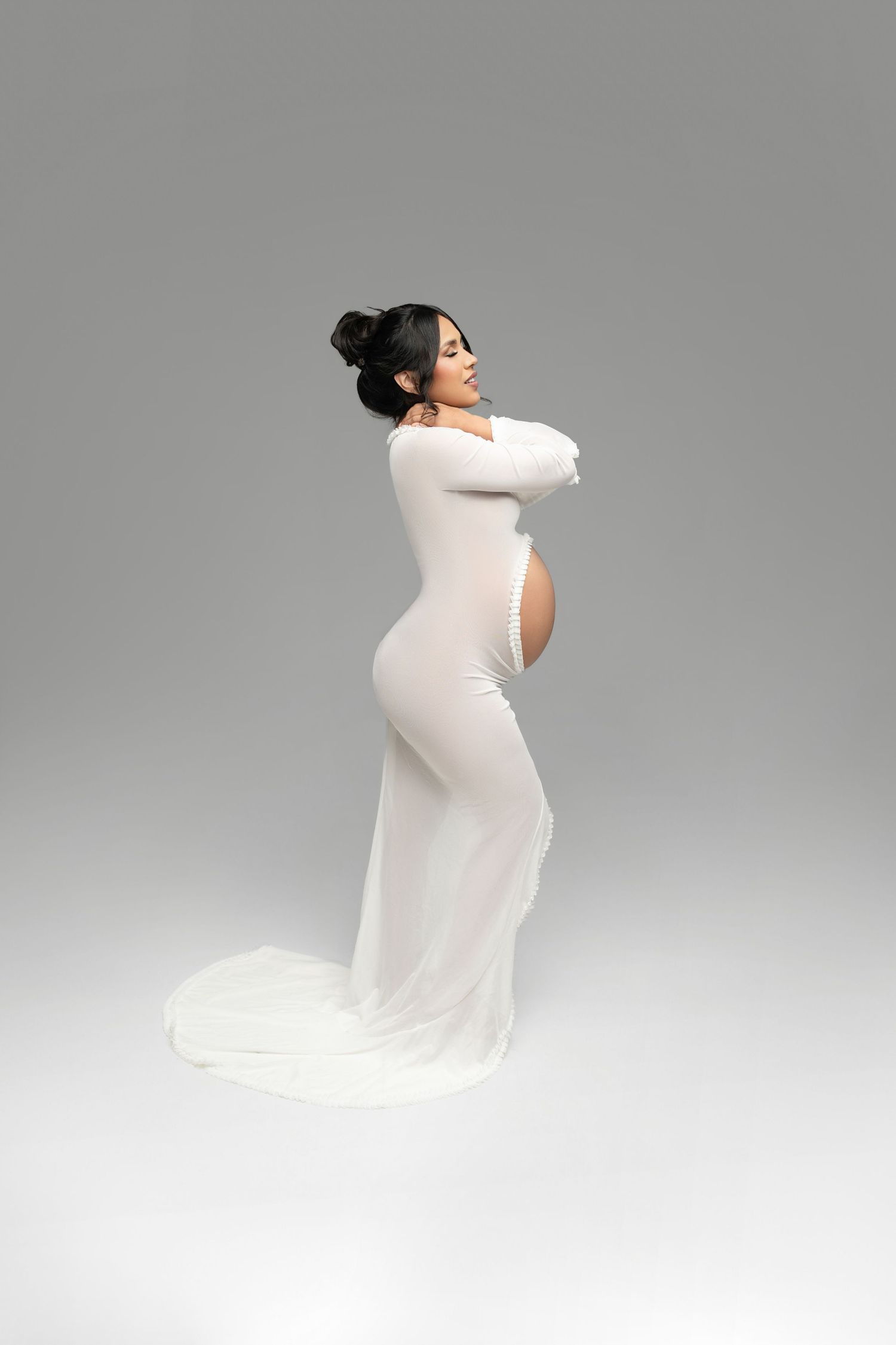 A figure in a flowing white dress poses gracefully against a gray background in a series of artistic movements.