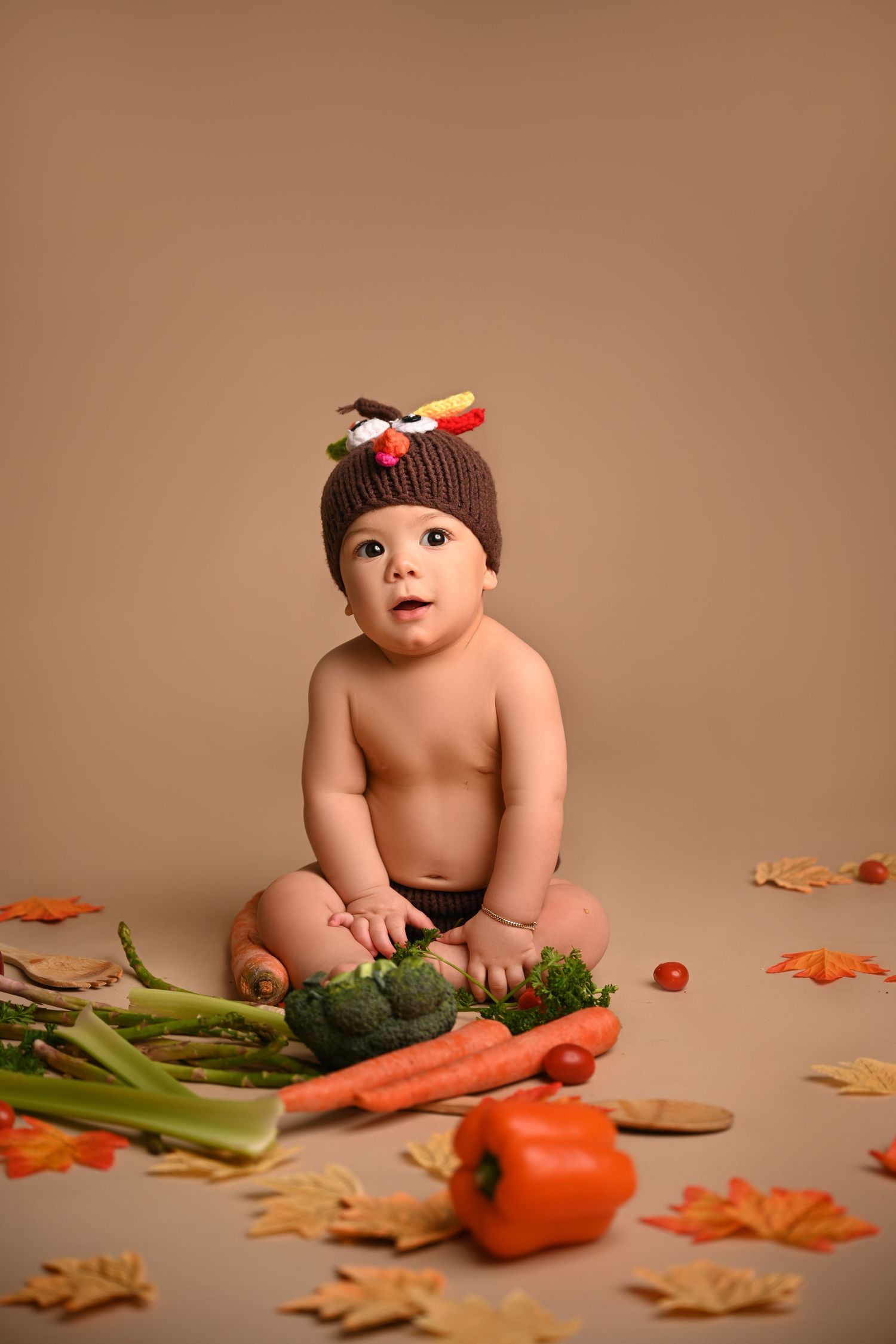 Fall themed photo with turkey hat and fresh vegetables on brown background.