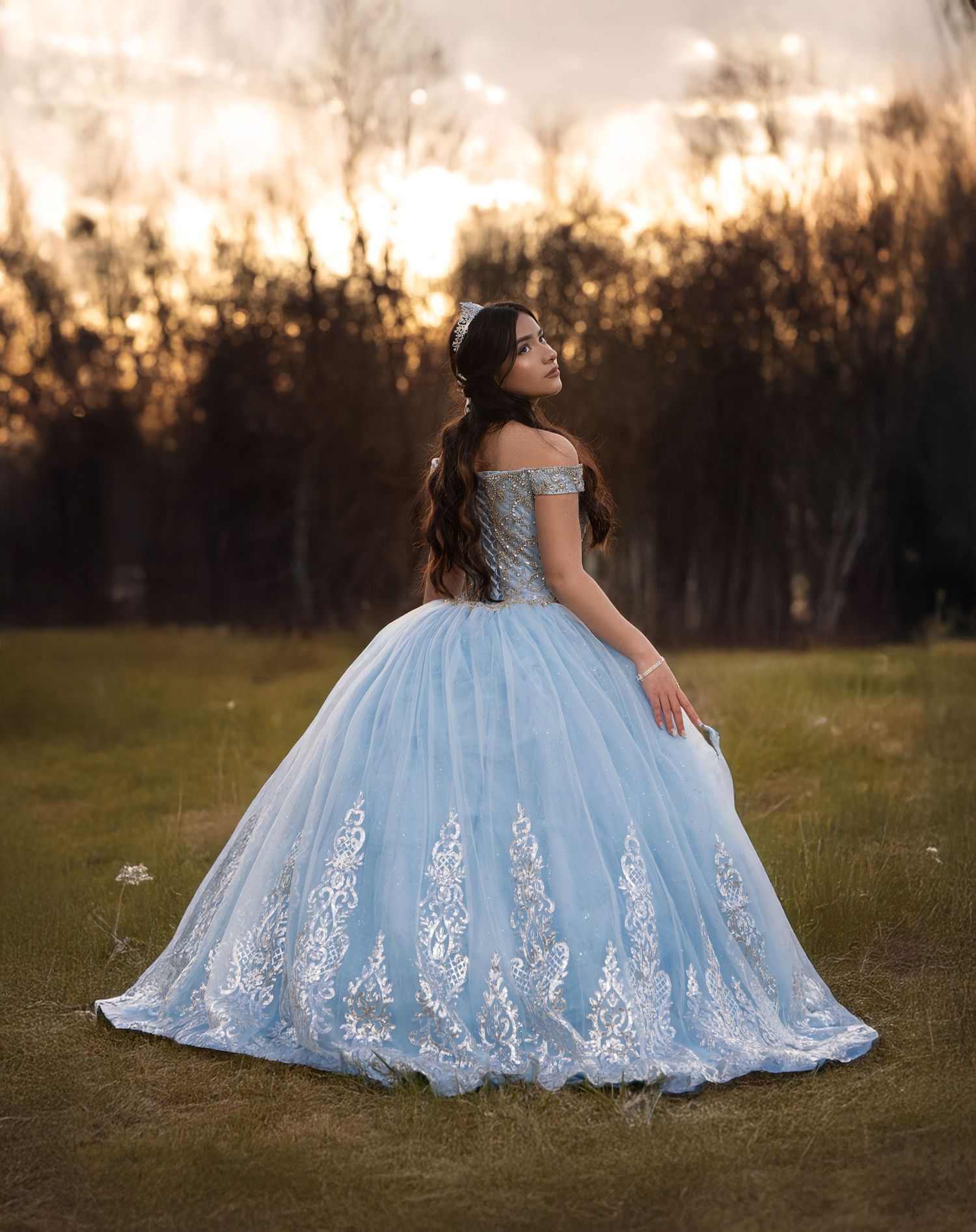 Beautiful blue ballgown with intricate lace details photographed at sunset.