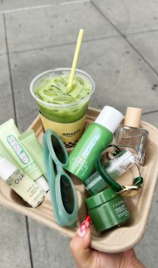 Green beauty products and skincare items arranged in a flatlay composition on a light surface.