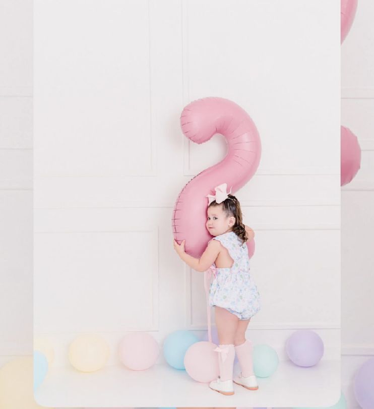 Minimalist birthday setup with soft pastel colors and a large pink number against white background.