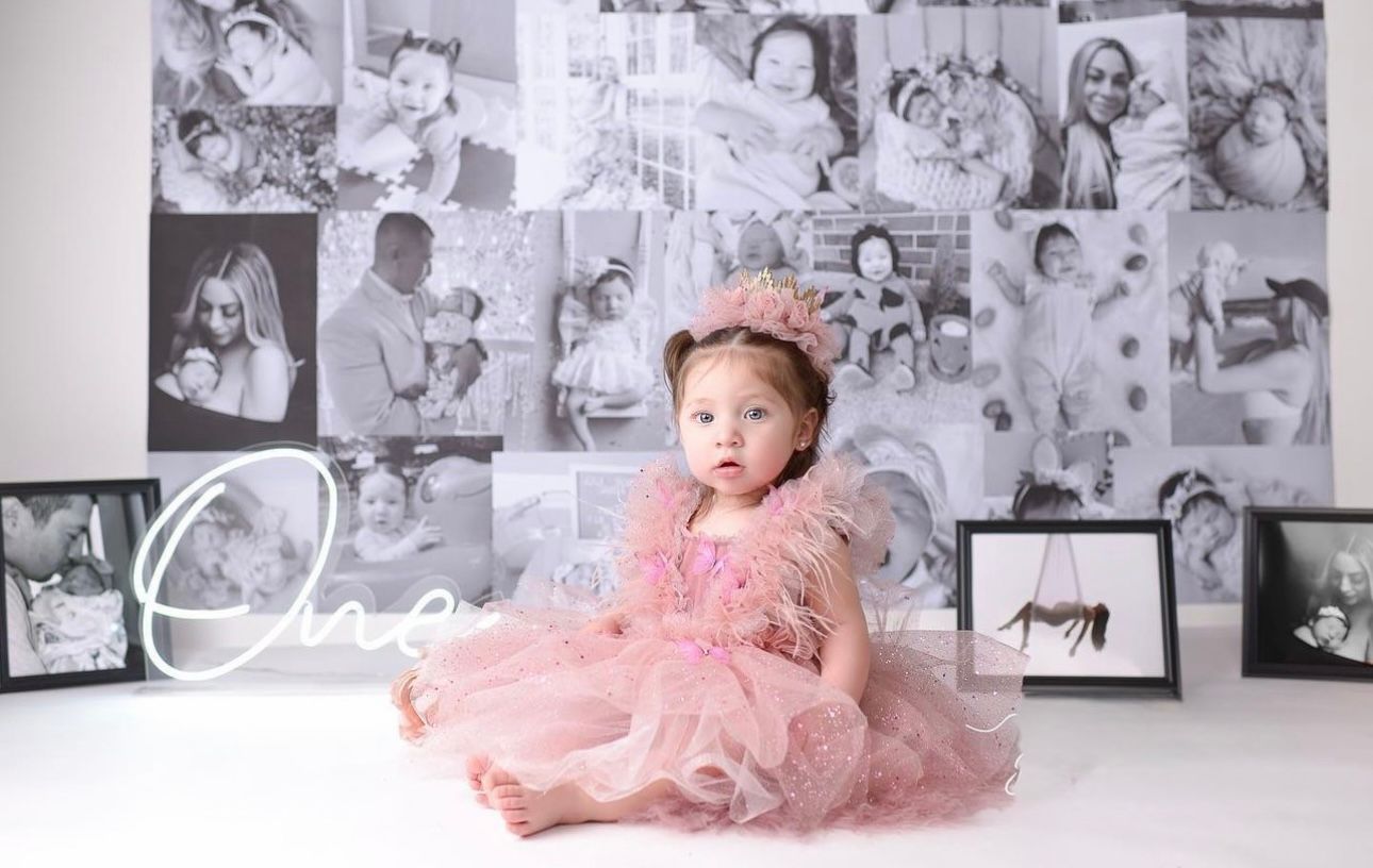 A collage of black and white photographs alongside a color photo of a baby in a pink tutu dress on white backdrop.